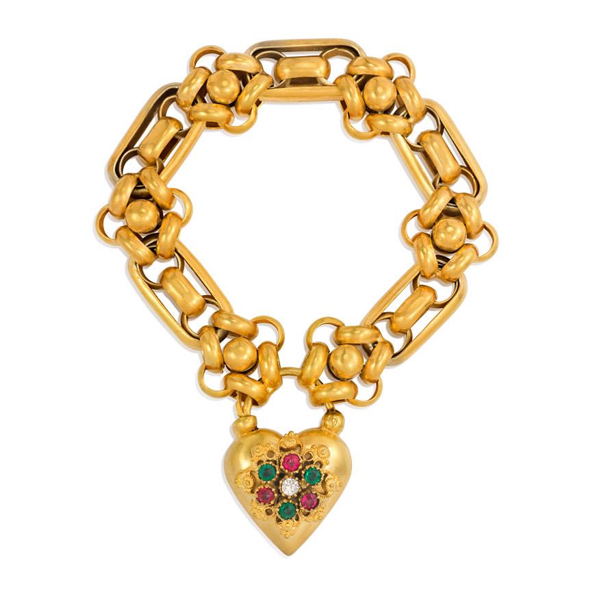 An antique pinchbeck necklace of interlocking oval and circular ringed links with half-ball spacers, completed by a heart-shaped padlock clasp decorated with emerald, ruby, and white paste atop a filigreed pattern.

20 1/2 inches long, 13/16 inch at