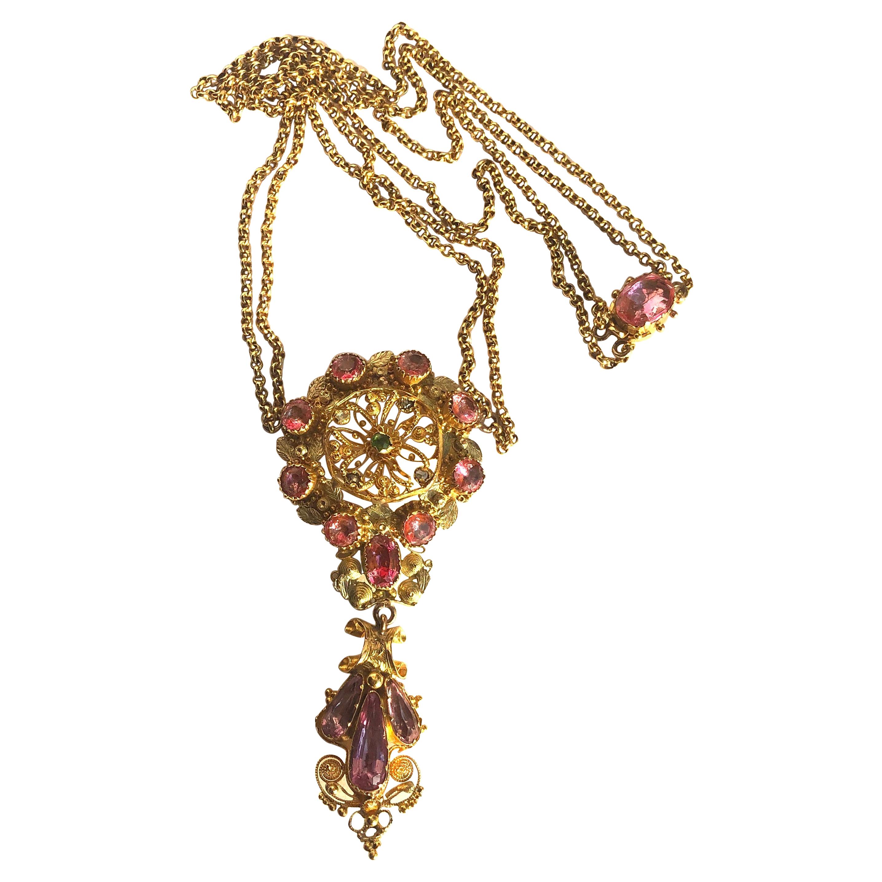 The metal work detail in this necklace is exquisite! The pendant itself holds a peridot stone at the centre and surrounding it there are fur small rose cut diamonds. The pendant is edged with pink topaz measuring 30pts and there is a drop holding