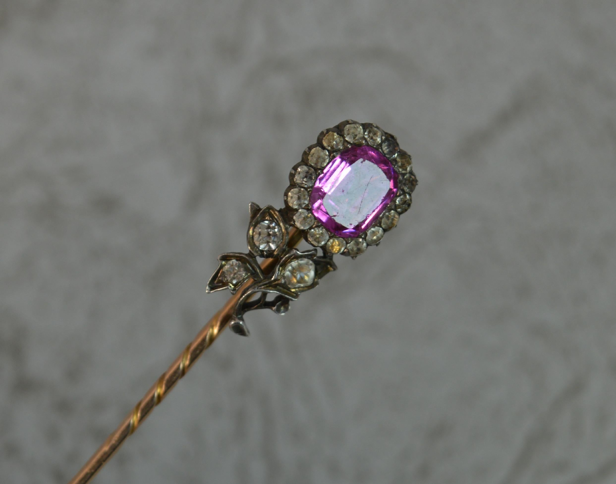 A beautiful Georgian era stick pin. Circa 1790.
​Designed with a flower top set with large vibrant emerald cut pink paste stone to the centre of white pastes. A flower cluster design.
Solid 15 carat rose gold pin and silver head.
​66mm long, 9mm x