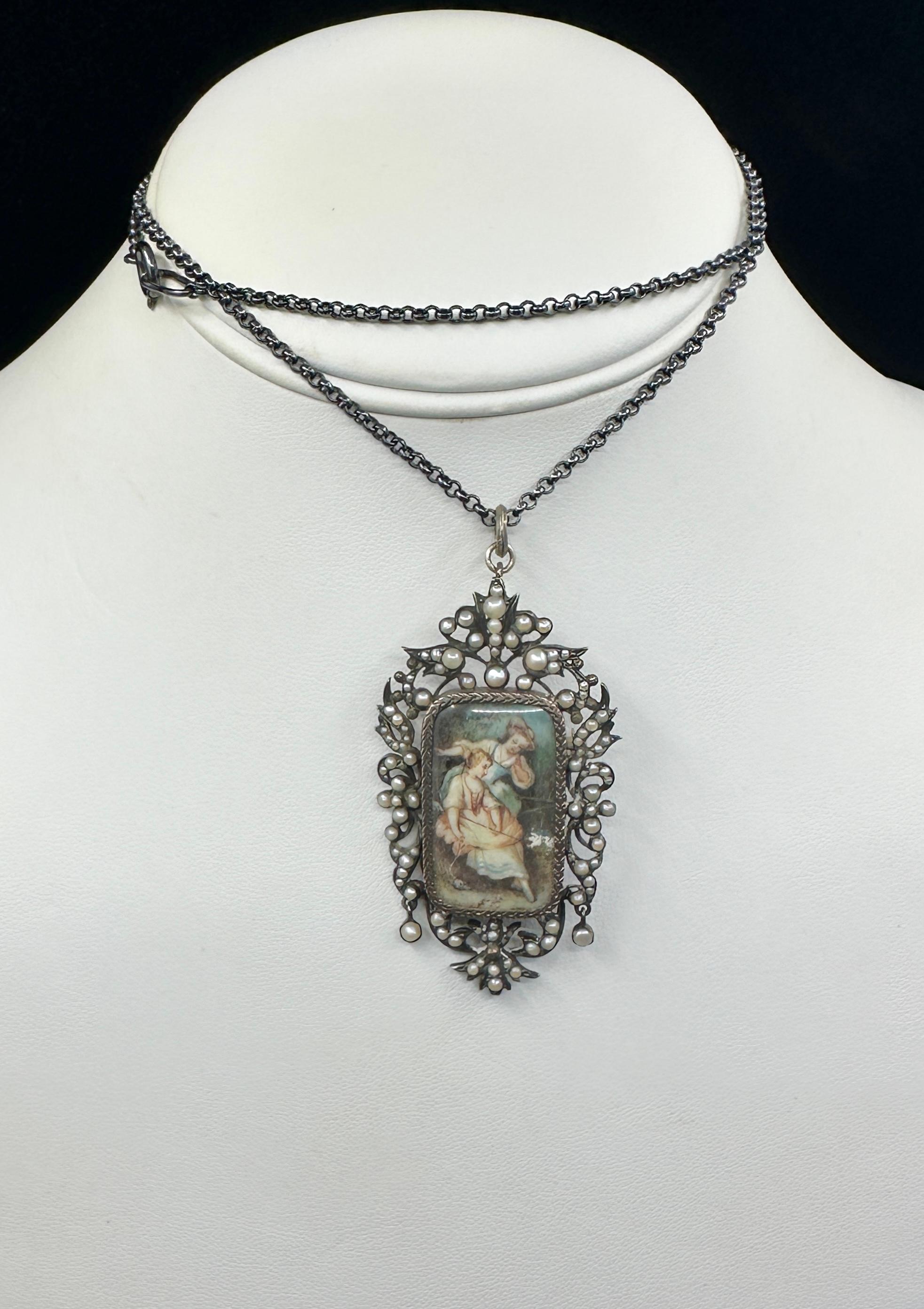 Lasciati conquistare da questa romantica collana o spilla georgiana con ciondolo di perle con ritratto di donna e uccellino in argento risalente al 1830 circa.   Il magnifico ciondolo georgiano è incentrato su uno splendido ritratto dipinto a mano