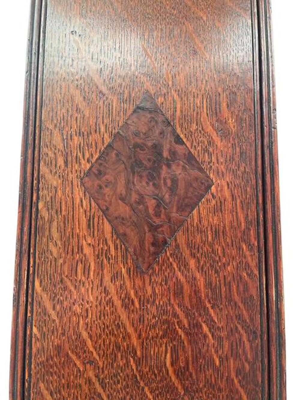 Quarter sawn oak slide lid candle box of rectangular form with the back board extending above and pierced for hanging. The nicely figured lid with reeded edges inlaid with a burr walnut diamond in the center and quarter rounds in each corner. (Small
