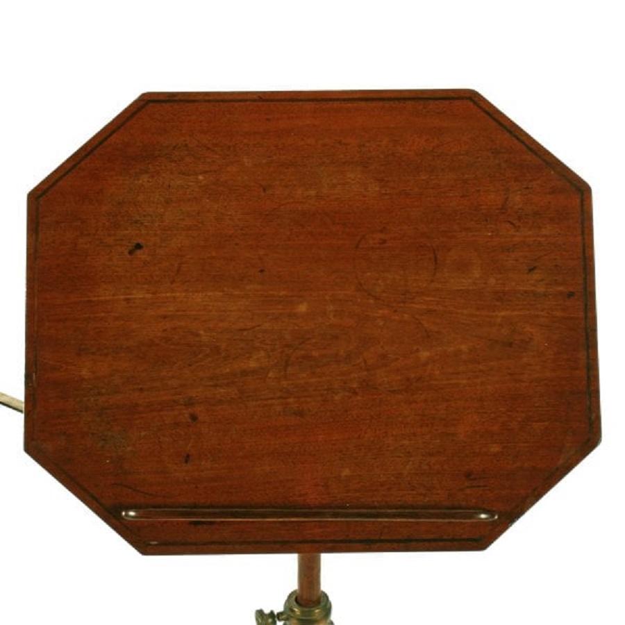 An early 19th century Georgian adjustable mahogany reading or music stand.

The stand has an octagonal top with line inlay, a removable book rest and at the side a brass candlestick arm.

The top can be adjusted in height and the angle can be
