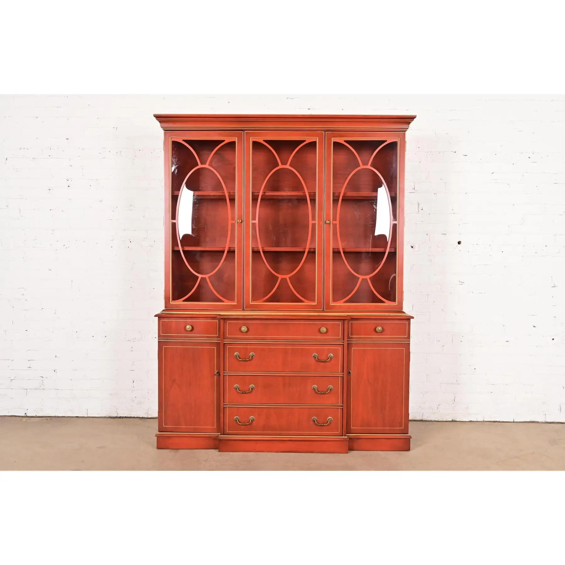 Uno splendido mobile libreria illuminato in stile georgiano o Chippendale con scrivania a ribalta

Di Jasper Cabinet Co.

USA, circa anni '1970

Legno di ciliegio intagliato e laccato rosso, con finiture dorate, ante a bifora e ferramenta originale