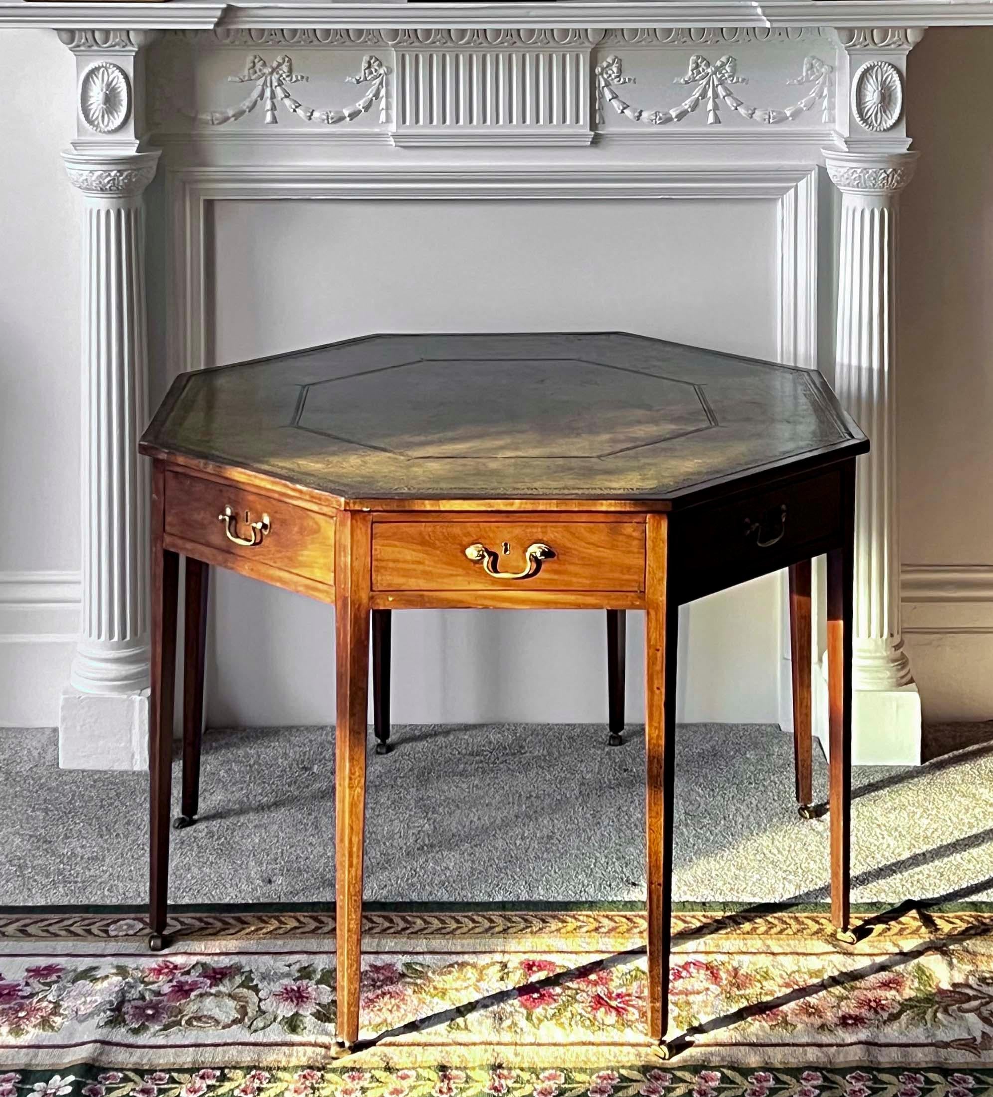 Une élégante table de bibliothèque octogonale de la fin de la période George III - début de la période Regency, avec un plateau doublé de cuir vert vieilli et quatre tiroirs.
Anglais, vers 1800.

Pourquoi nous l'aimons
Insolite et élégamment