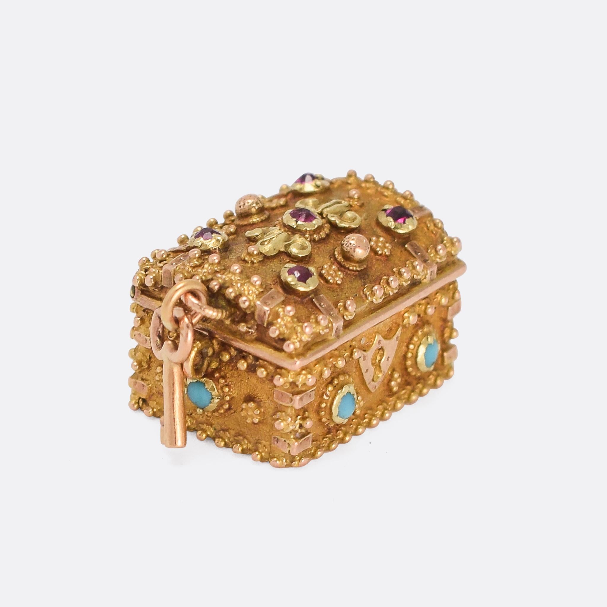 Treasure! A wonderful Regency Period charm locket modelled as a treasure chest. It's beautifully worked in two-tone gold, with applied granulation and exquisite details. It's set with ruby and turquoise cabochons, and opens up to reveal a concave