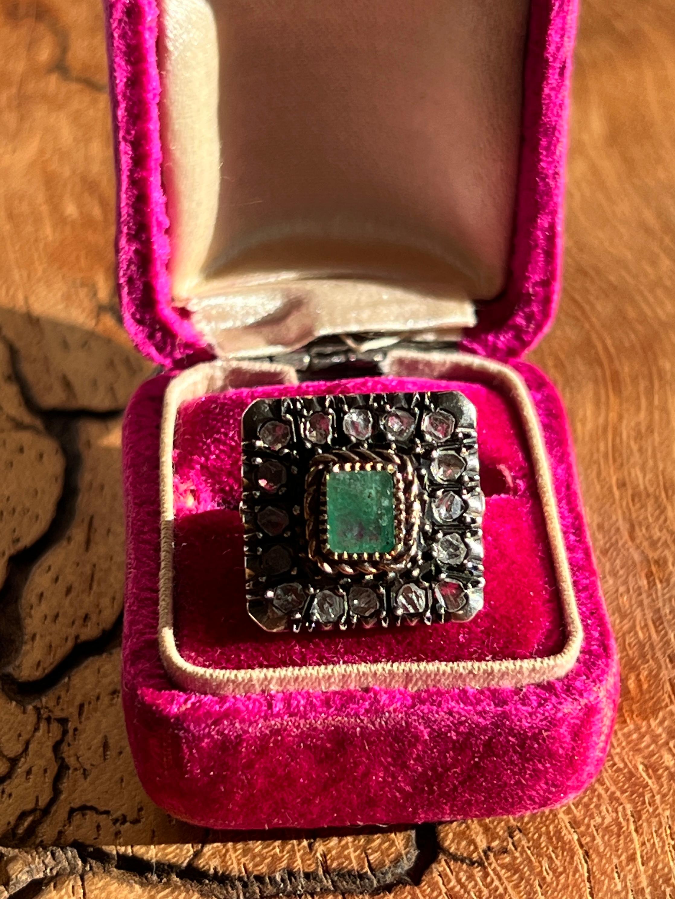 Cette bague de reproduction géorgienne vintage présente une émeraude taillée en émeraude et un halo de diamants bruts, offrant le charme romantique du design du début du XIXe siècle avec la durabilité de l'artisanat du milieu du XXe siècle. La bague