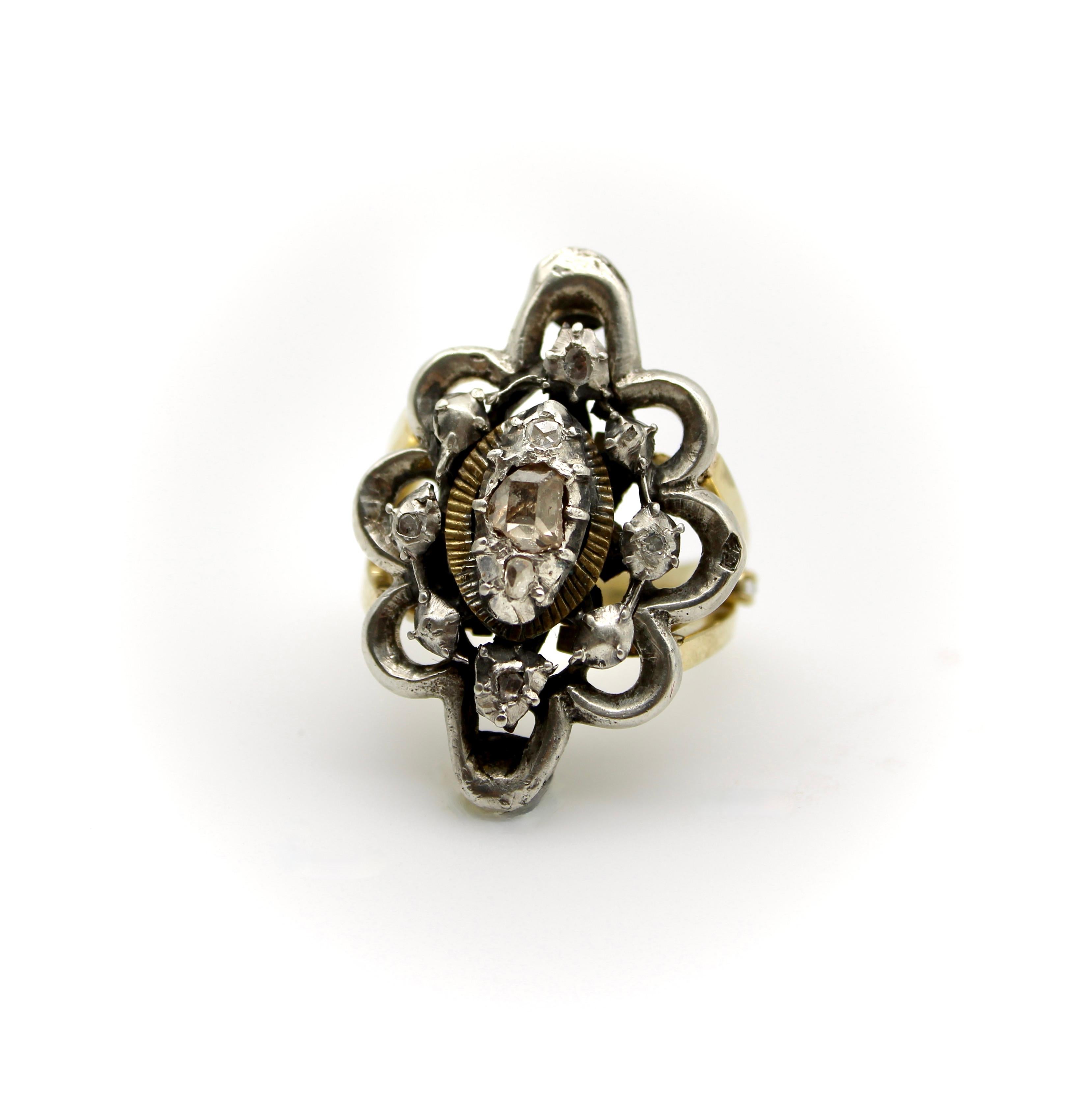 This exquisite ring has a Georgian Revival sterling silver diamond flower top, with a custom made 14k yellow gold band. The sterling silver flower has a beautiful table cut (flat top) diamond that is collect set in the center of the ring. Around the