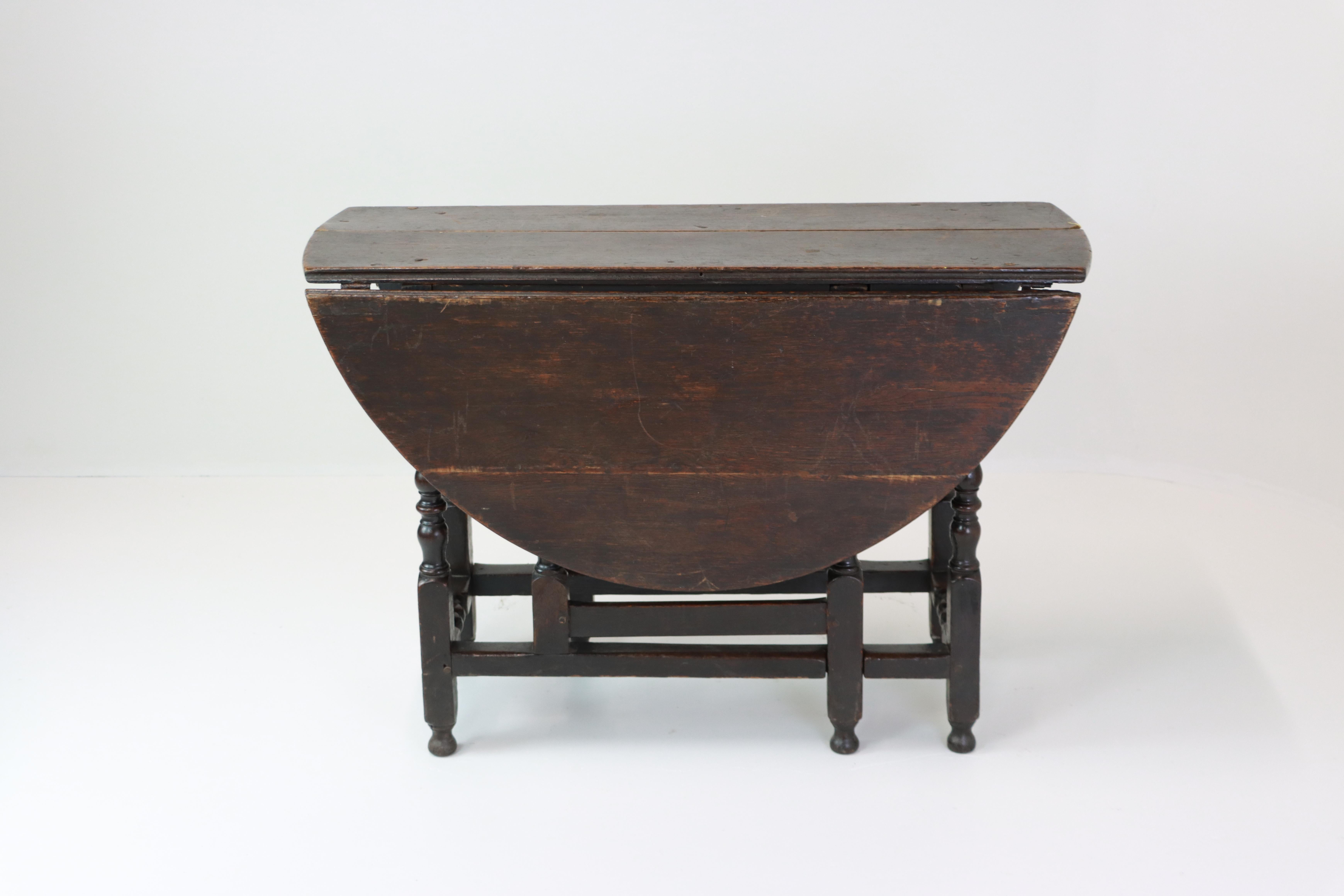 English oak gateleg table with classic barley twist supports. The rectangular top with rounded drop leaves opens to form an oval surface, with beautifully turned spiral legs joined by box stretchers. Rich, dark oak patina shows the with wear and