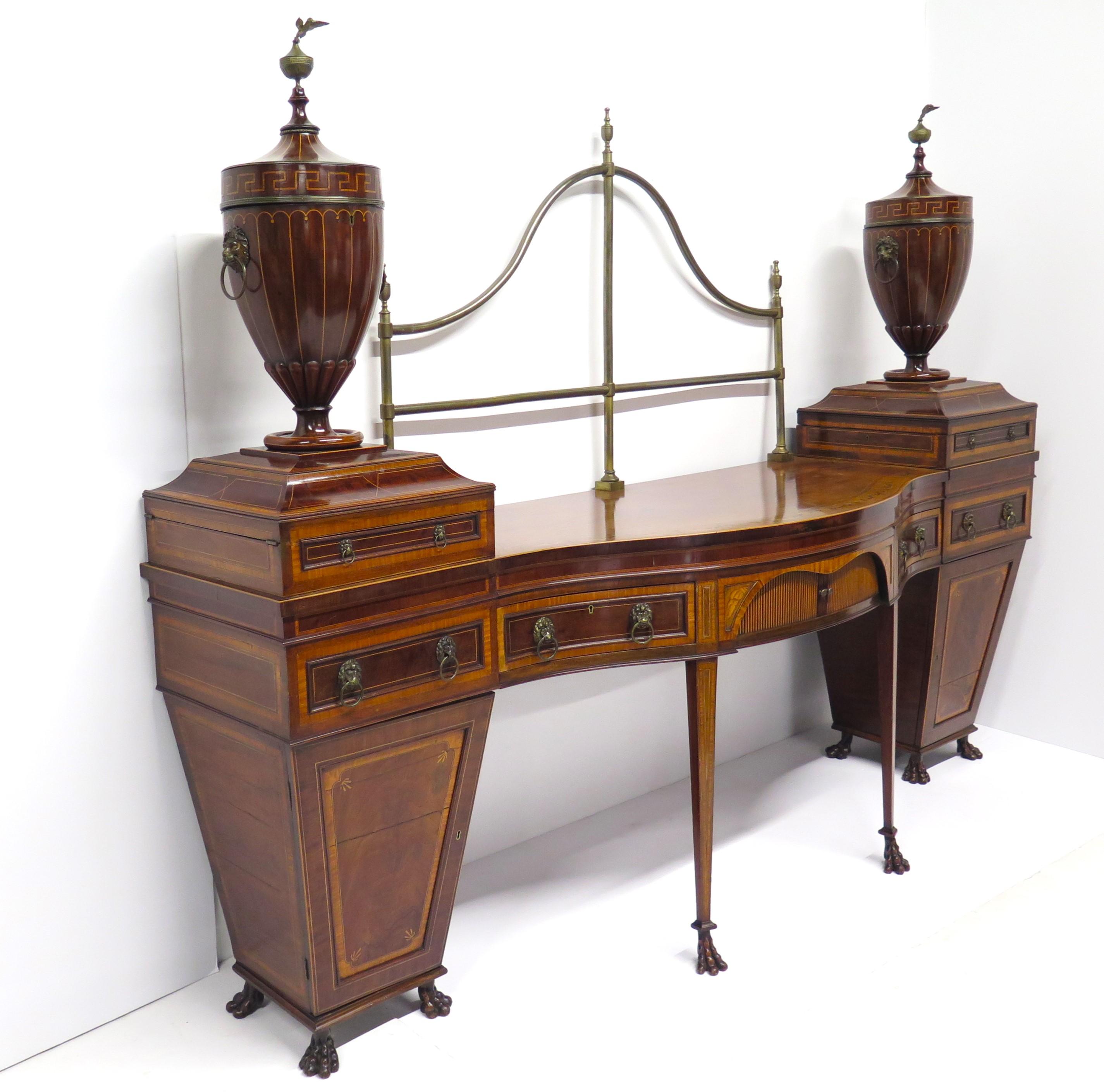 An exceptional Georgian revival mahogany sideboard with arched back brass railing, sideboard is of rectangular form with bow front and faded mahogany top with marquetry of bows and swags, twin pedestals of satinwood crossbanding with ebony and