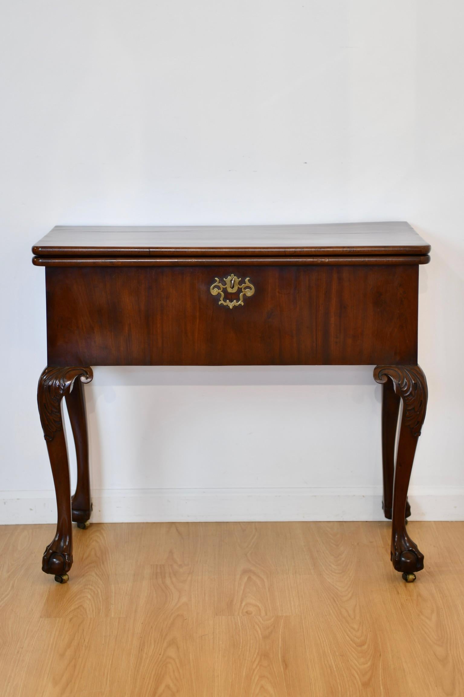 Georgian revival harlequin mechanical transforming desk that, when closed, is in the form of console table. When opened and the back legs extended, the table becomes a games table with salmon pink suede inset surface. When games surface is folded,