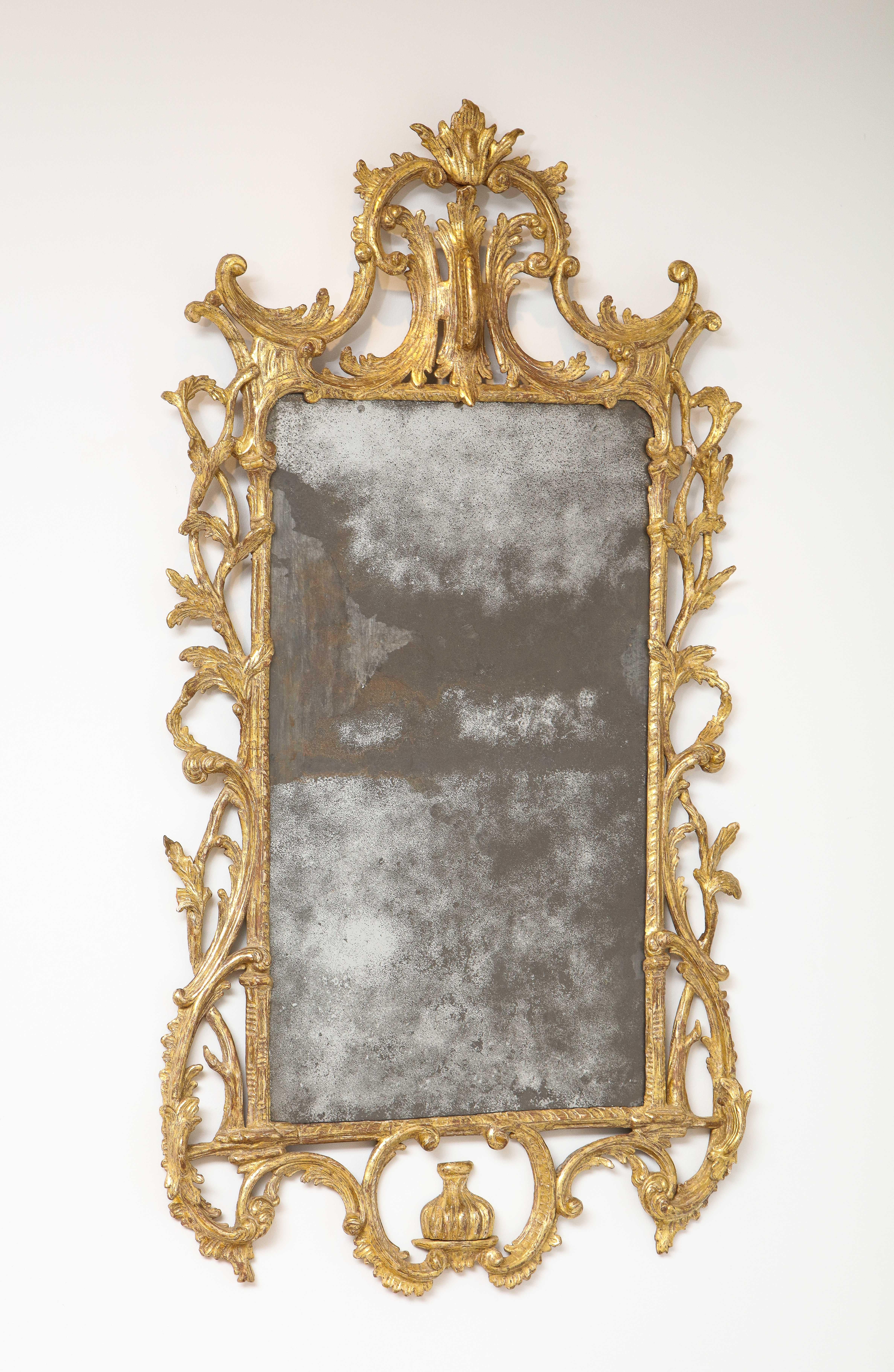 Fine George III period giltwood looking glass, retaining its original mercury plate, having lovely dry scraped original gilding on a foliate and rocaille carved frame, the whole with pleasing old surface.
 