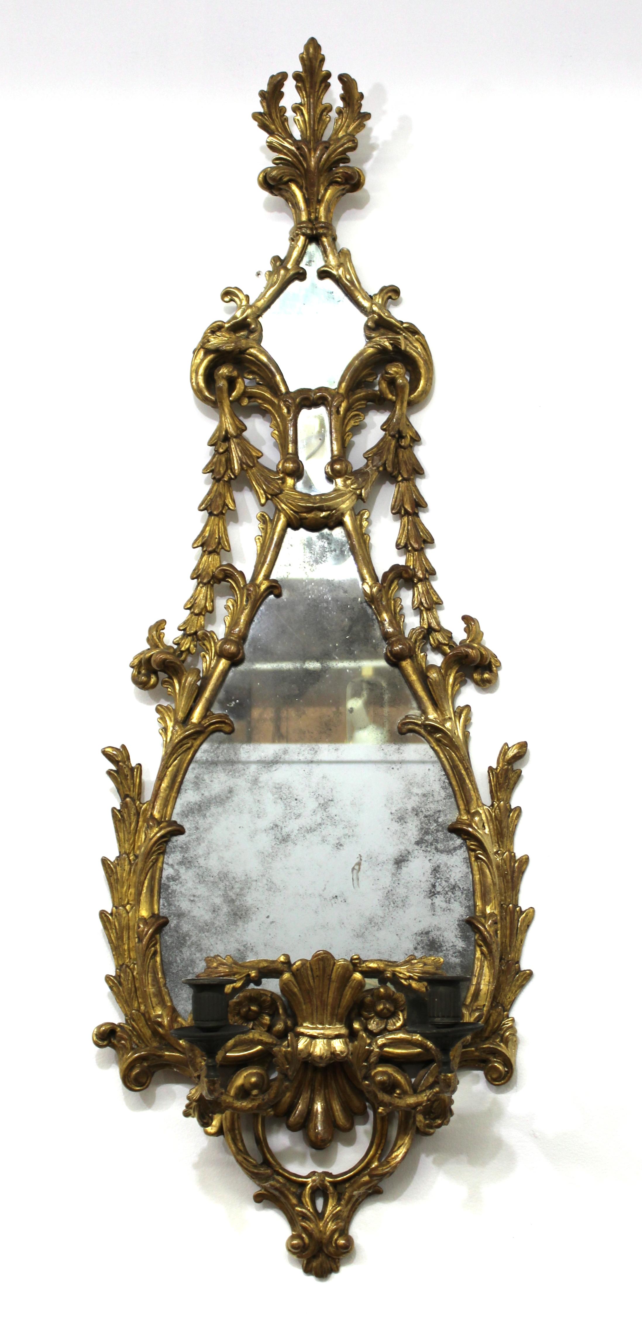 English Rococo George III style pair of carved giltwood mirrored girandole candle sconces with elaborate foliage and acanthus leaves. Two candle sockets on each sconce. In great antique condition with age-appropriate wear and use.