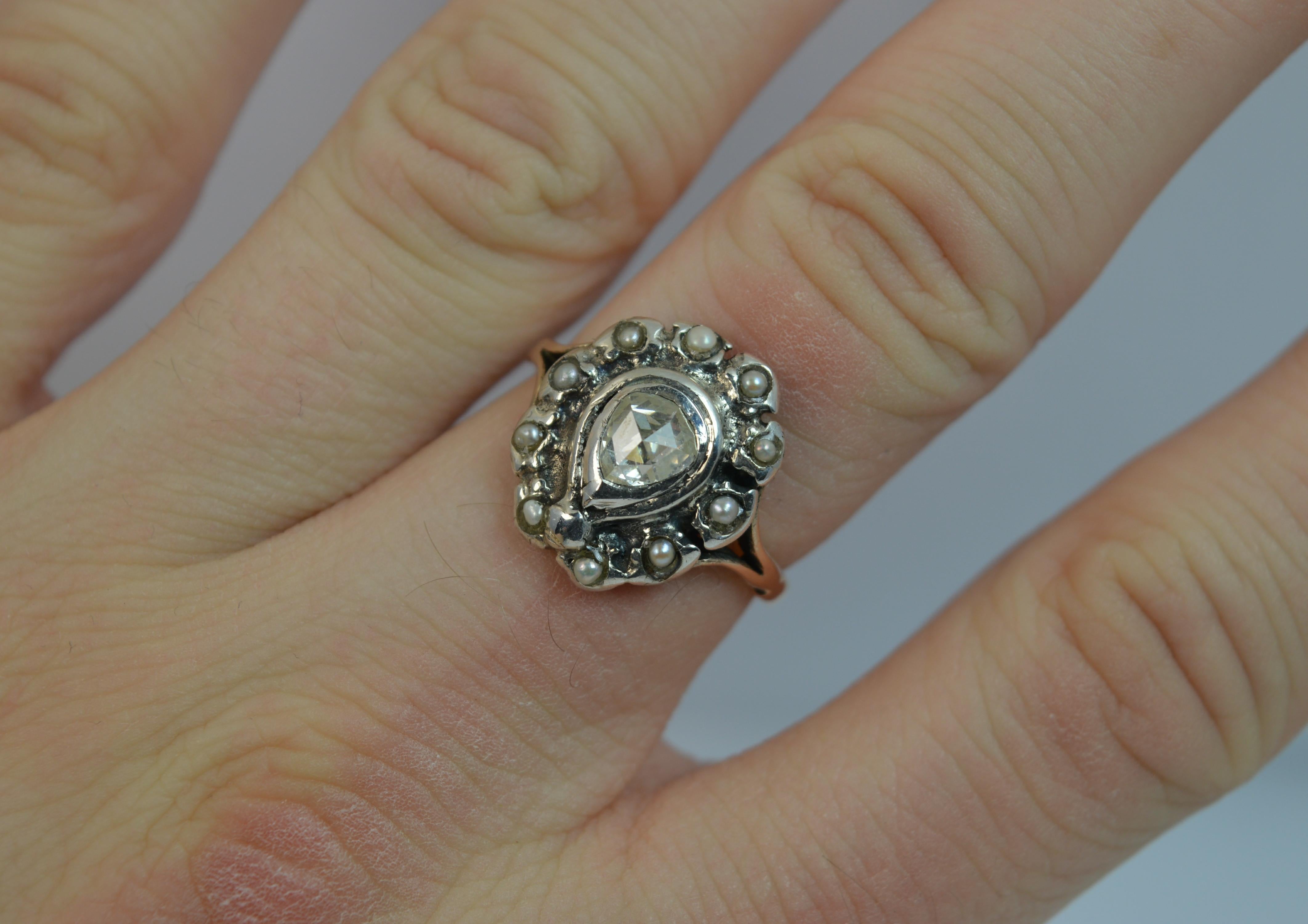 A genuine George III period cluster ring.
SIZE ; N 1/2 UK, 7 US
Modelled in 15 carat rose gold and a silver head setting typical of the period.
The rose cut pear shaped diamond to measure 5.3mm x 5.8mm approx, approx 0.70 spread with full seed pearl