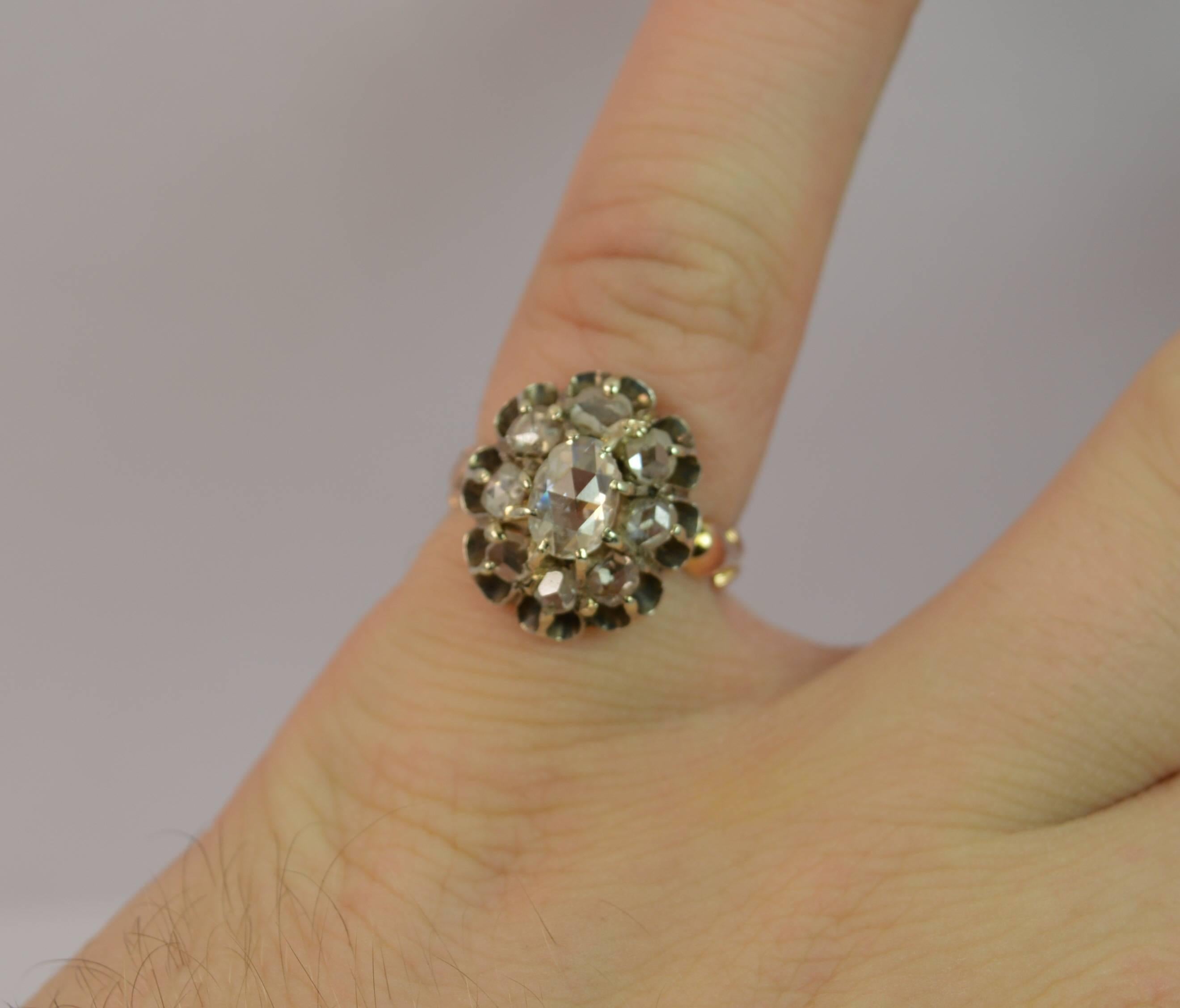 
An antique diamond cluster ring.

This example is set with a large oval rose cut diamond to the centre in an eight claw mount, 4.5mm x 6.5mm, spreading .65 carats.

A further eight rose cut diamonds surround in the silver head to form a 12mm x