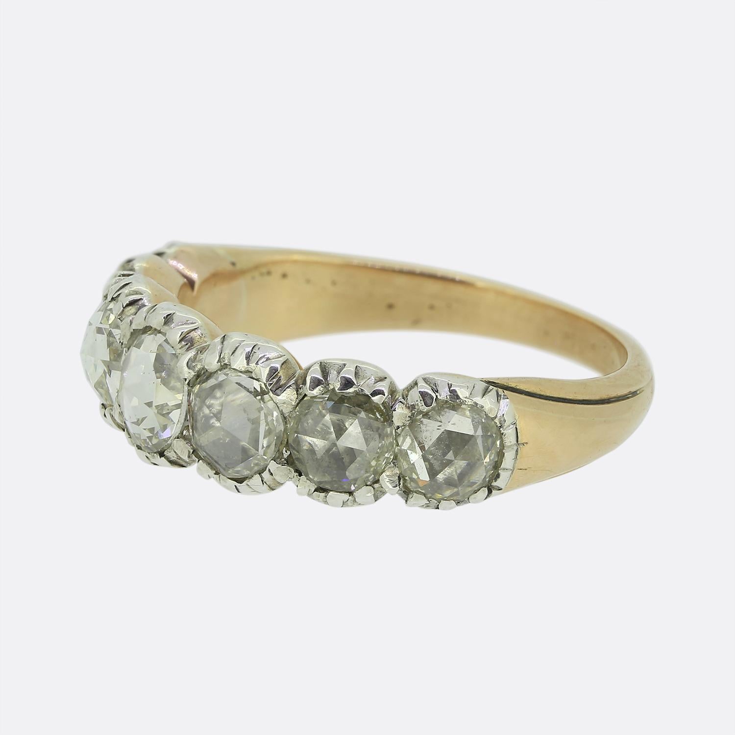 Here we have a charming band ring featuring a single row of rose-cut diamonds. Crafted during the Georgian period, each stone has been securely set in silver, showcasing their unique facets and subtle sparkle atop a closed backing. The diamonds are