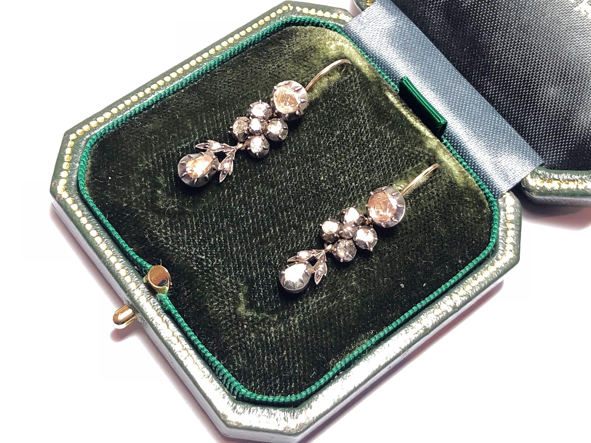 A pair of Georgian, rose-cut diamond drop earrings, with a rose-cut diamond top, with five rose-cut diamonds set in the middle and a drop shaped rose-cut diamond pendant, with rose-cut diamond set leaves, mounted in silver-upon-gold cut down