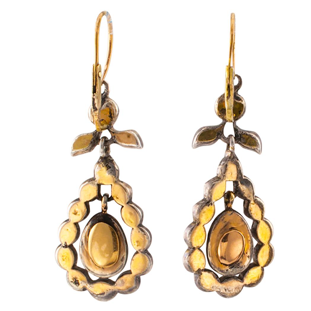 Antique Georgian rose cut diamonds gold and silver dangling earring. The articulated designs are surmounted by foliar motifs suspending open teardrop-shaped elements, set throughout with rose-cut diamonds, mounted in silver over 15-karat gold with