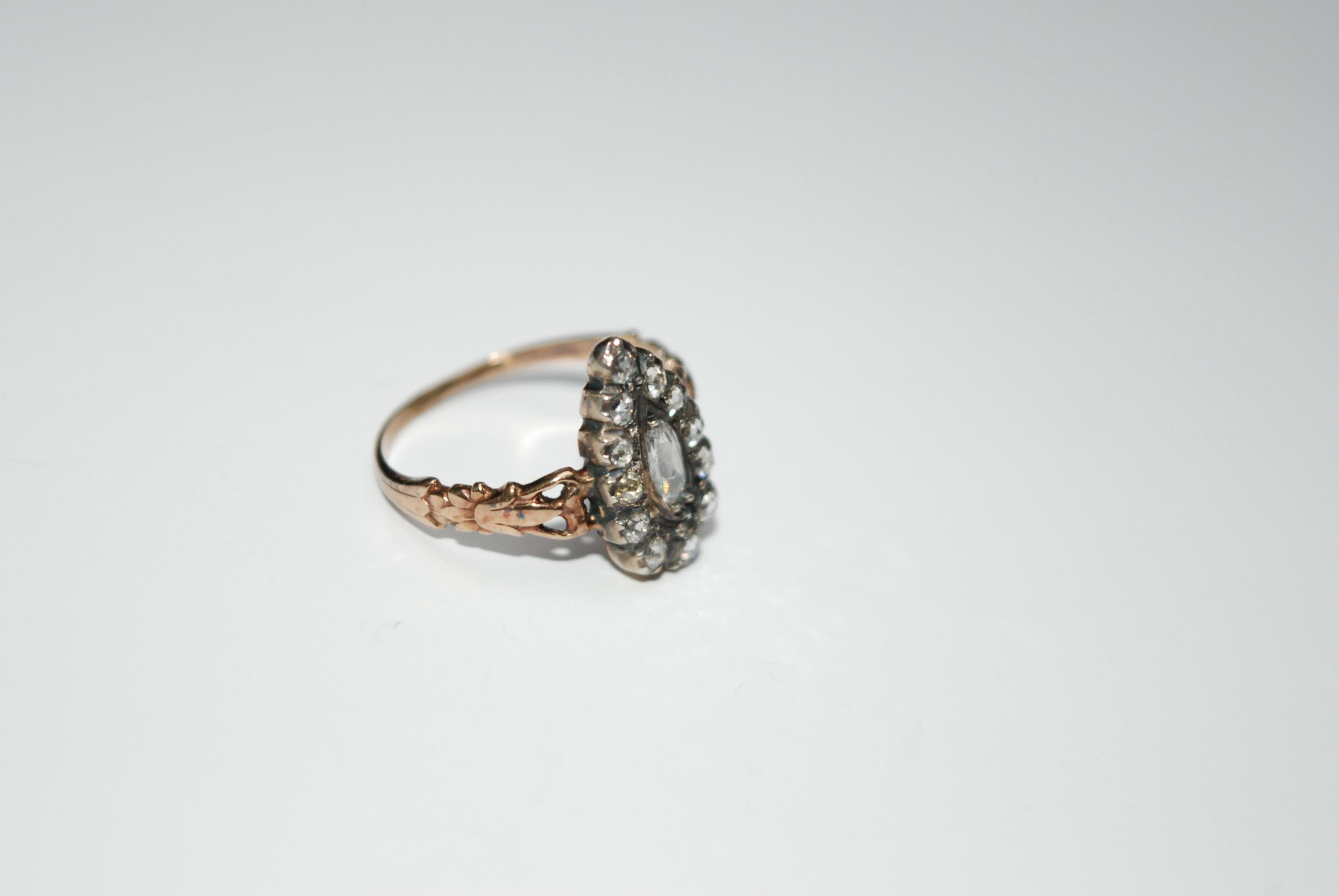 Anello in oro rosa smerigliato con diamante a forma di marquise, caratterizzato da un diamante centrale a forma di marquise circondato da diamanti a taglio rosa. 
Le spalle sono ornate da intagli con motivi floreali e naturali. 

Ridimensionabile