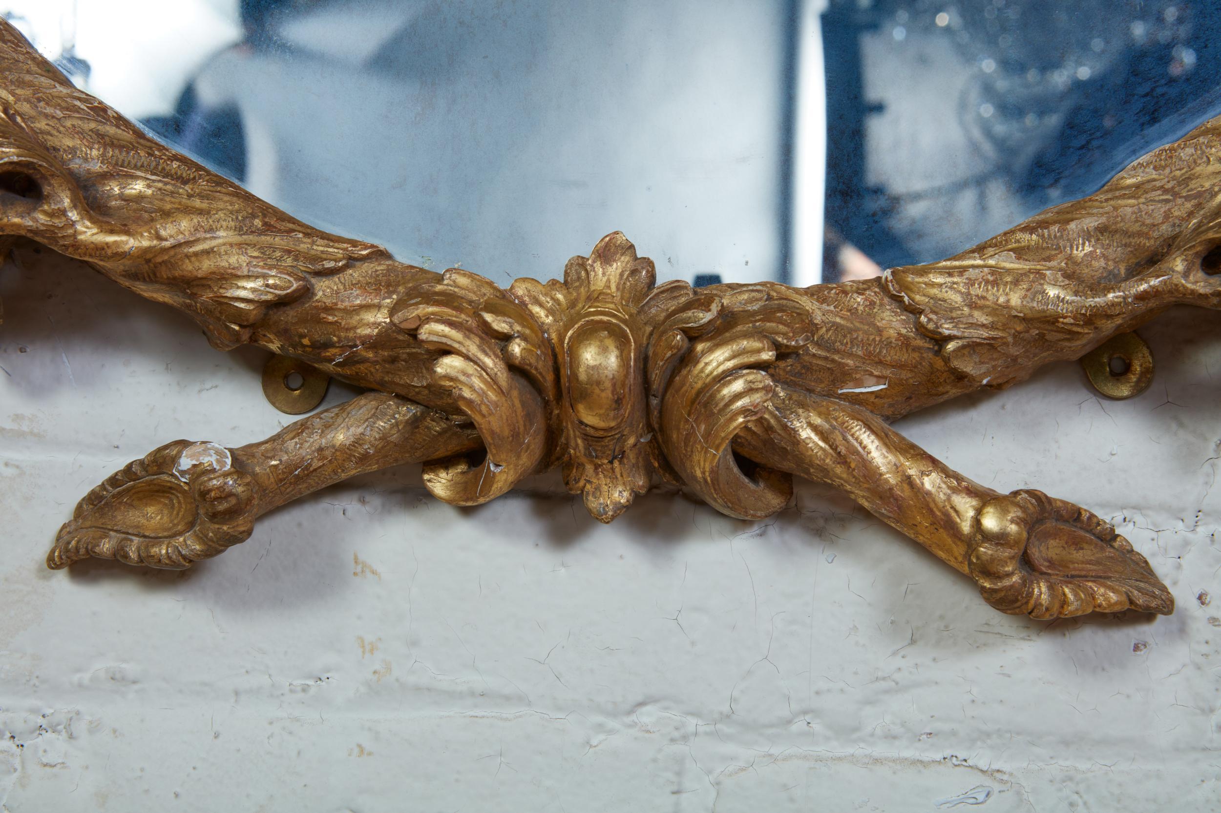 Très beau miroir George III en bois sculpté et doré à la manière de John Linnell, comprenant deux branches de chêne liées par un ruban formant une couronne, ornées de glands et de rustications finement détaillées. Les miroirs géorgiens ronds sont