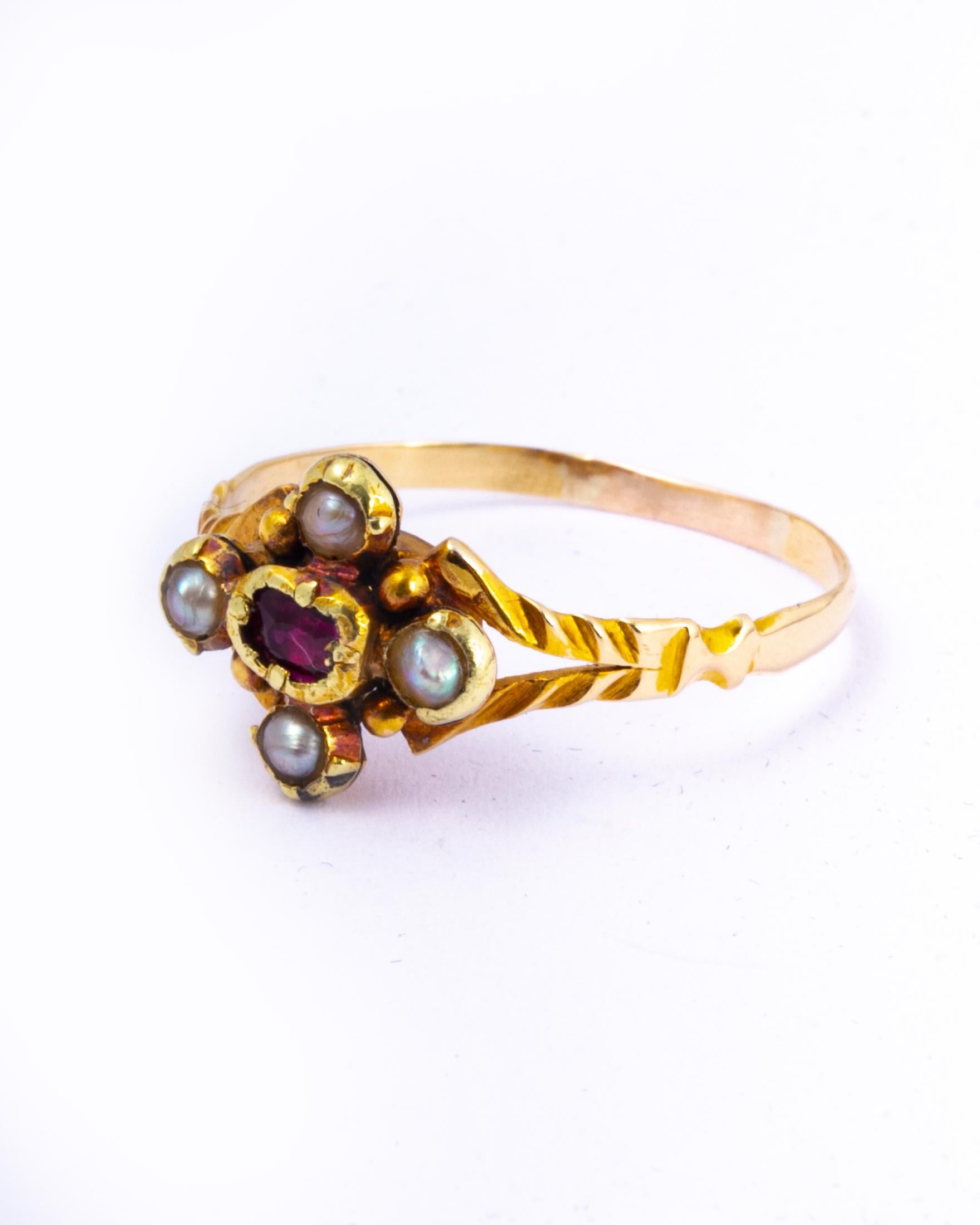 A spectacular antique Georgian ring. Centred with a wonderful ruby bordered on all sides by beautiful pearls. The split shoulders have wonderful texture and moulded detail. Modelled in 15 carat yellow gold.

Ring Size: N or 6 3/4 
Widest Point: