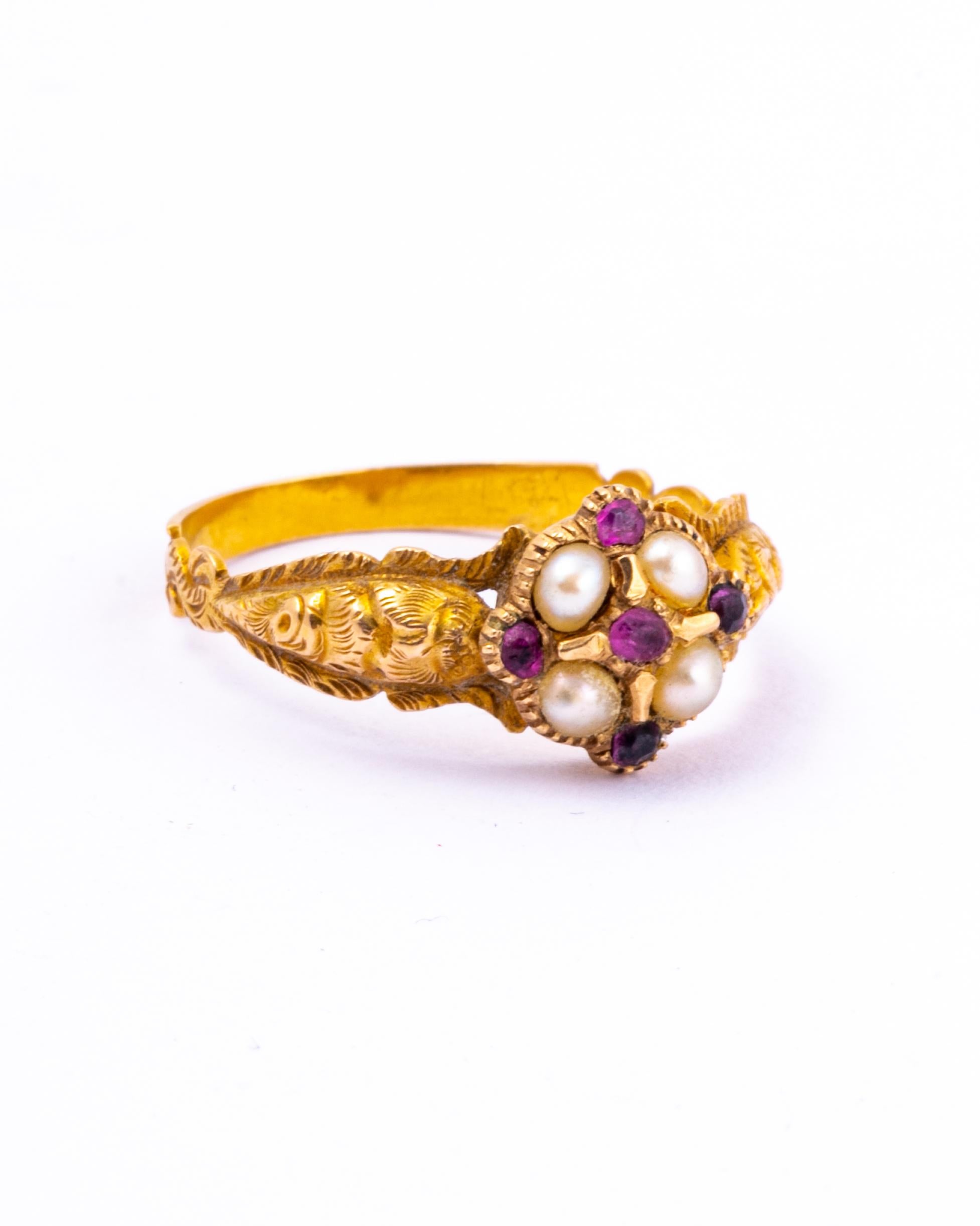 A spectacular antique Georgian ring. At the centre of four pearls is a small ruby with rubies in-between each pearl on the outside. The moulded shoulders have wonderful texture and engraved detail. Modelled in 18 carat yellow gold.

Ring Size: Q 1/2