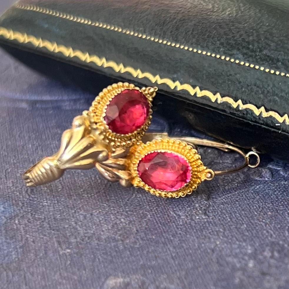 A pair of 18 karat gold antique Georgian poissarde earrings set with a faceted ruby-colored paste glass stone. These are typically early 19th century French loop earrings worn by French fisherman's women.

The front of these earrings are decorated