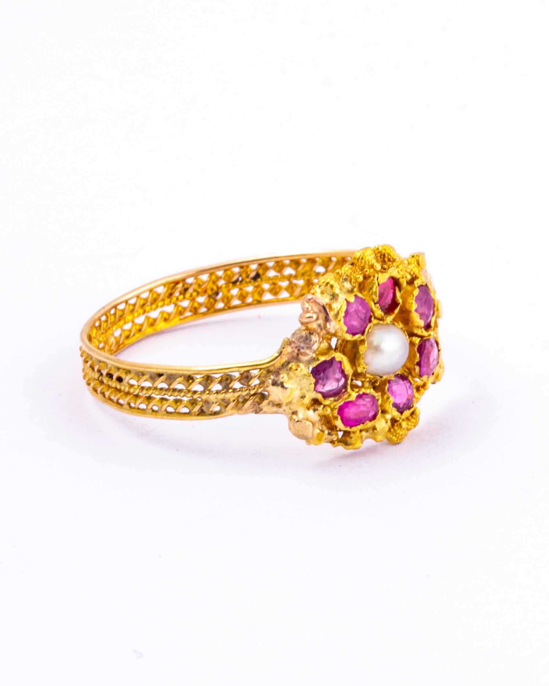 This stunning ring has so much detail. There are seven rose cut rubies and a pearl sat at the centre. Surrounding the stones is intricate cannetille work and the band is made up of fine twisted gold. 

Ring Size: R or 8 1/2 
Width: 11mm

Weight: 1.7g