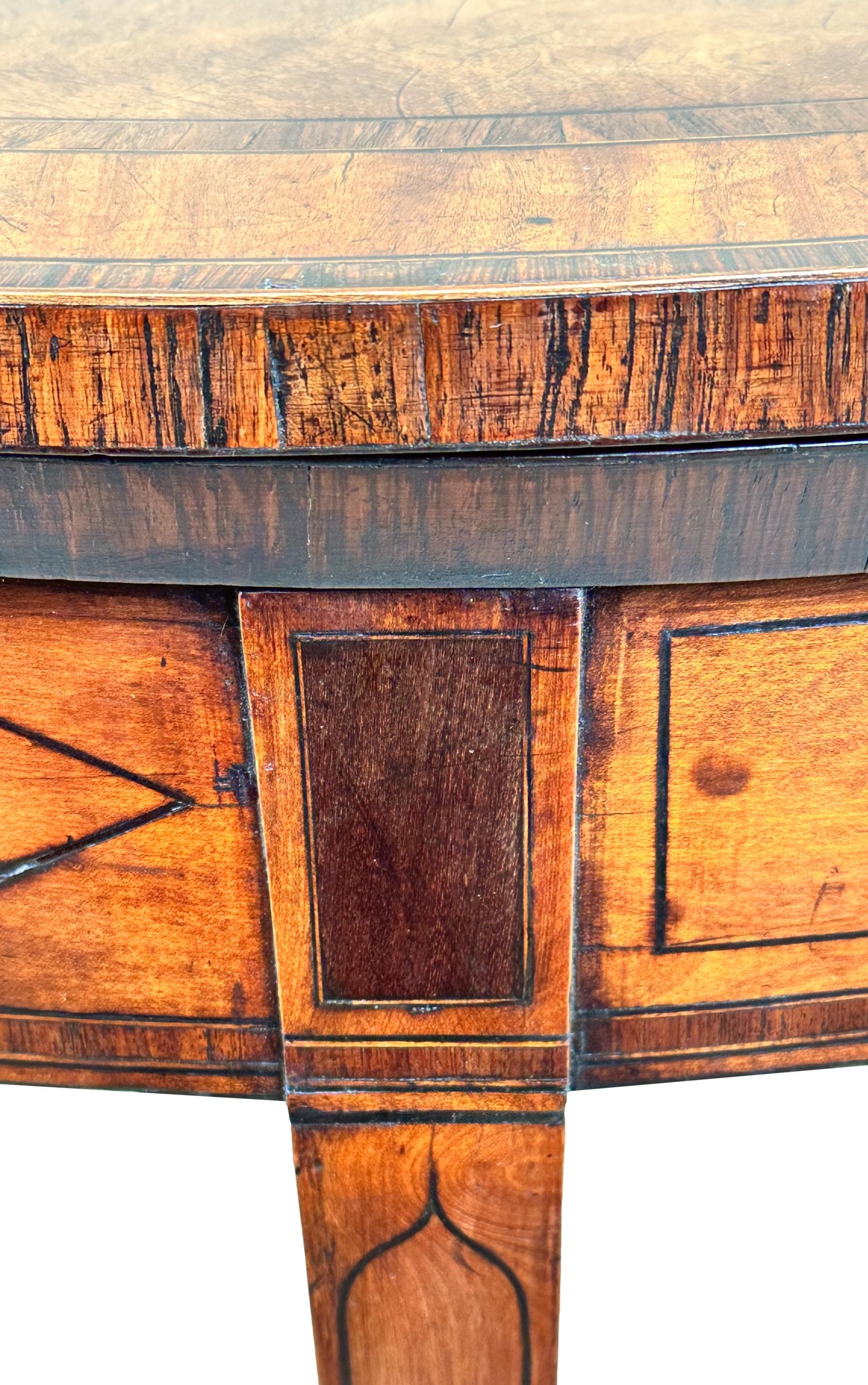 

A Very Good Quality George III, Sheraton Period, Satinwood Demi Lune Shaped Tea Table Having Exceptionally Well Figured Folding Top, With Wide Crossbanded Decoration, Over Inlaid Frieze Raised On Elegant Square Tapering Legs.

Tea tables, as the