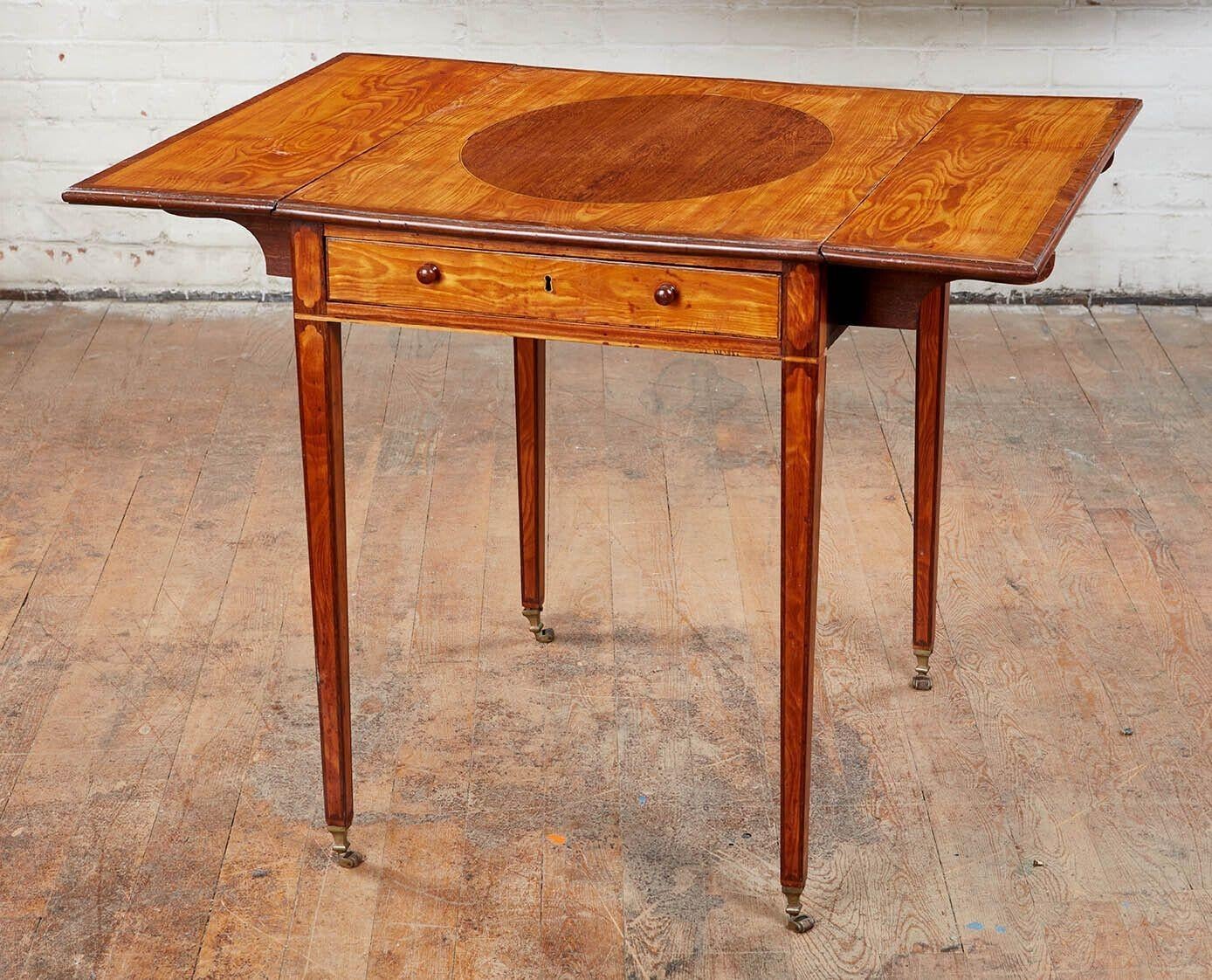 Very fine George III satinwood Pembroke table, the rectangular top with purpleheart oval center and cross banding, having two rectangular leaves similarly banded, over single divided drawer, standing on square tapered legs with inlaid panels,