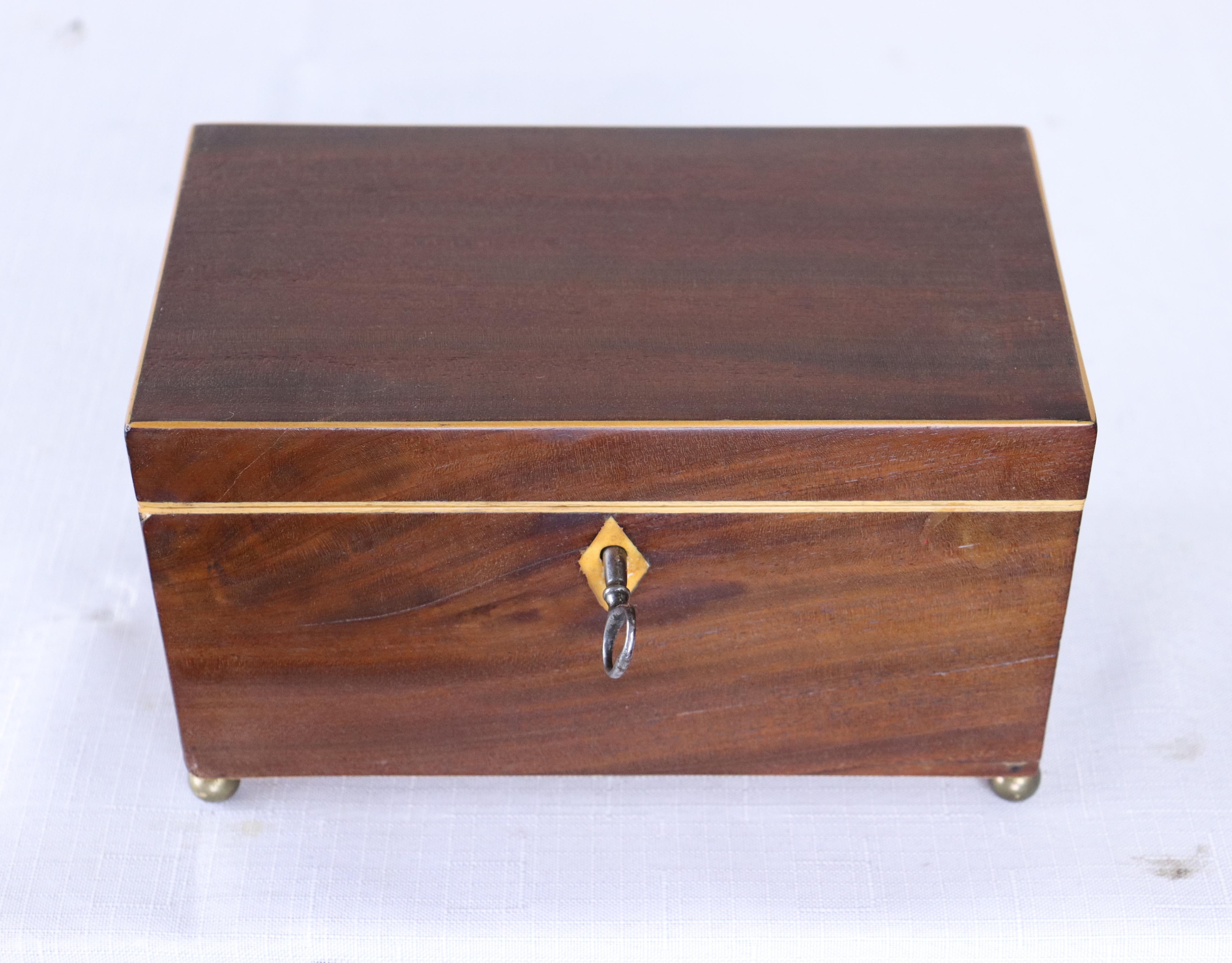 A beautiful Georgian tea caddy on charming ball feet. Two compartments inside with traces of the original paper. Good oak grain and nice patina all over. Original key.