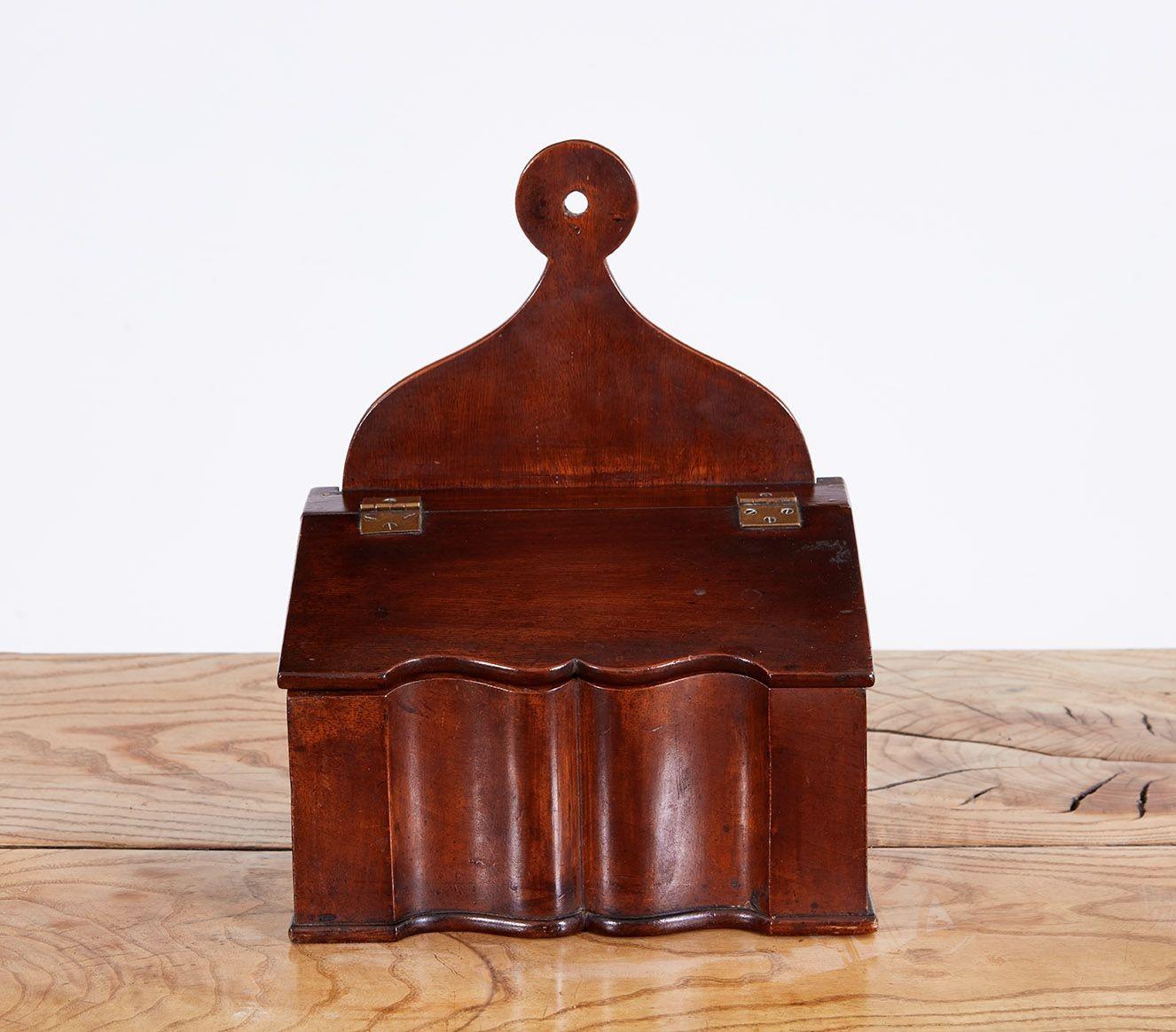 Fine English or American mahogany scalloped wall hanging salt box, having large penny mounting plate over sloped lid, the box with deeply scalloped body and molded base, good old surface and rich patina, original brass hinges. A little gem from an