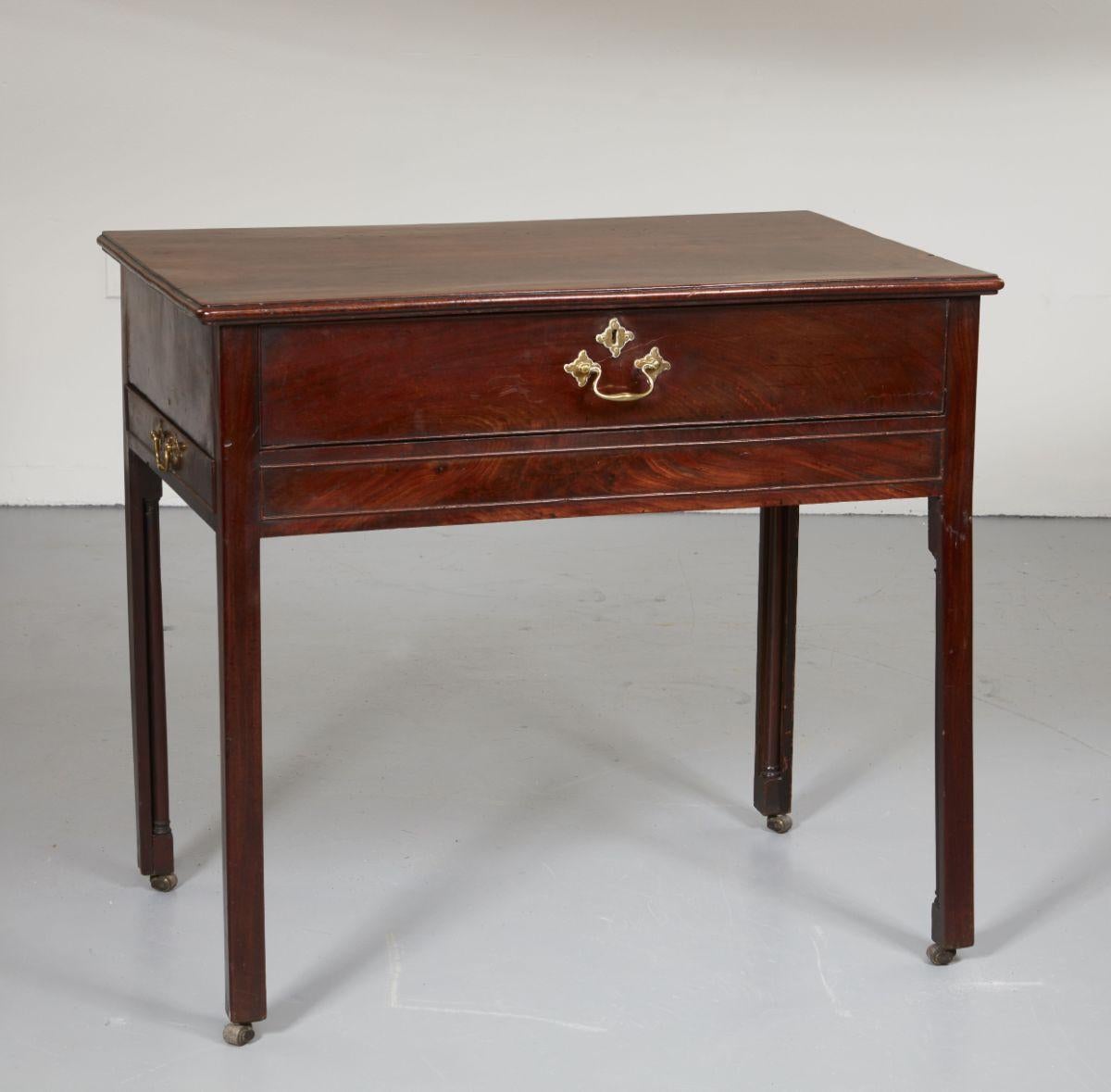 Very fine English George III country house mahogany architect's desk/library table having richly grained single board top with molded edge over single wide drawer with pull out and drop-down writing surface and drawers and pigeon holes and having