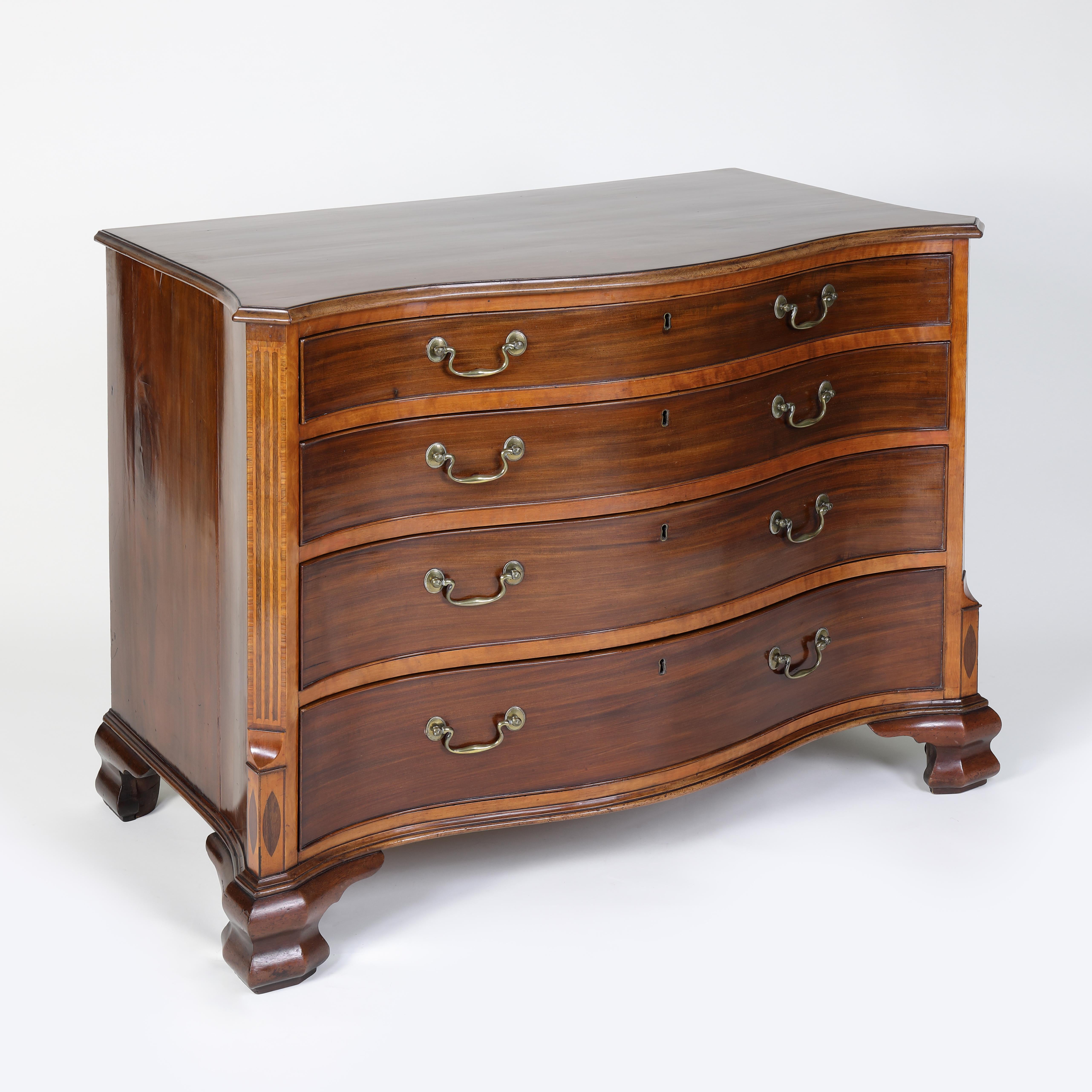 In The Manner of Ince and Mayhew
A fine quality mahogany serpentine shaped chest of drawers inlaid and cross-banded with satinwood. An incredibly smart and imposing commode in the manner of Ince and Mayhew. The shaped top with finely moulded edge