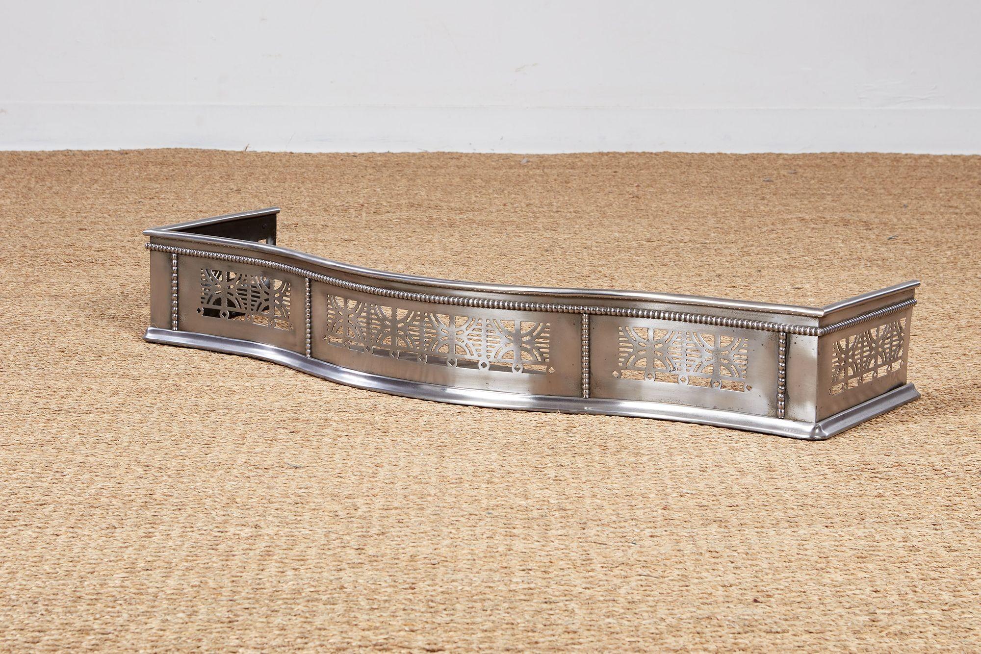 A handsome fire fender with a sinuous bow front in polished steel with decorative pierce-work, beading and cornice and shoe molding, all in cut steel.  An elegant accessory to dress up a fireplace. 