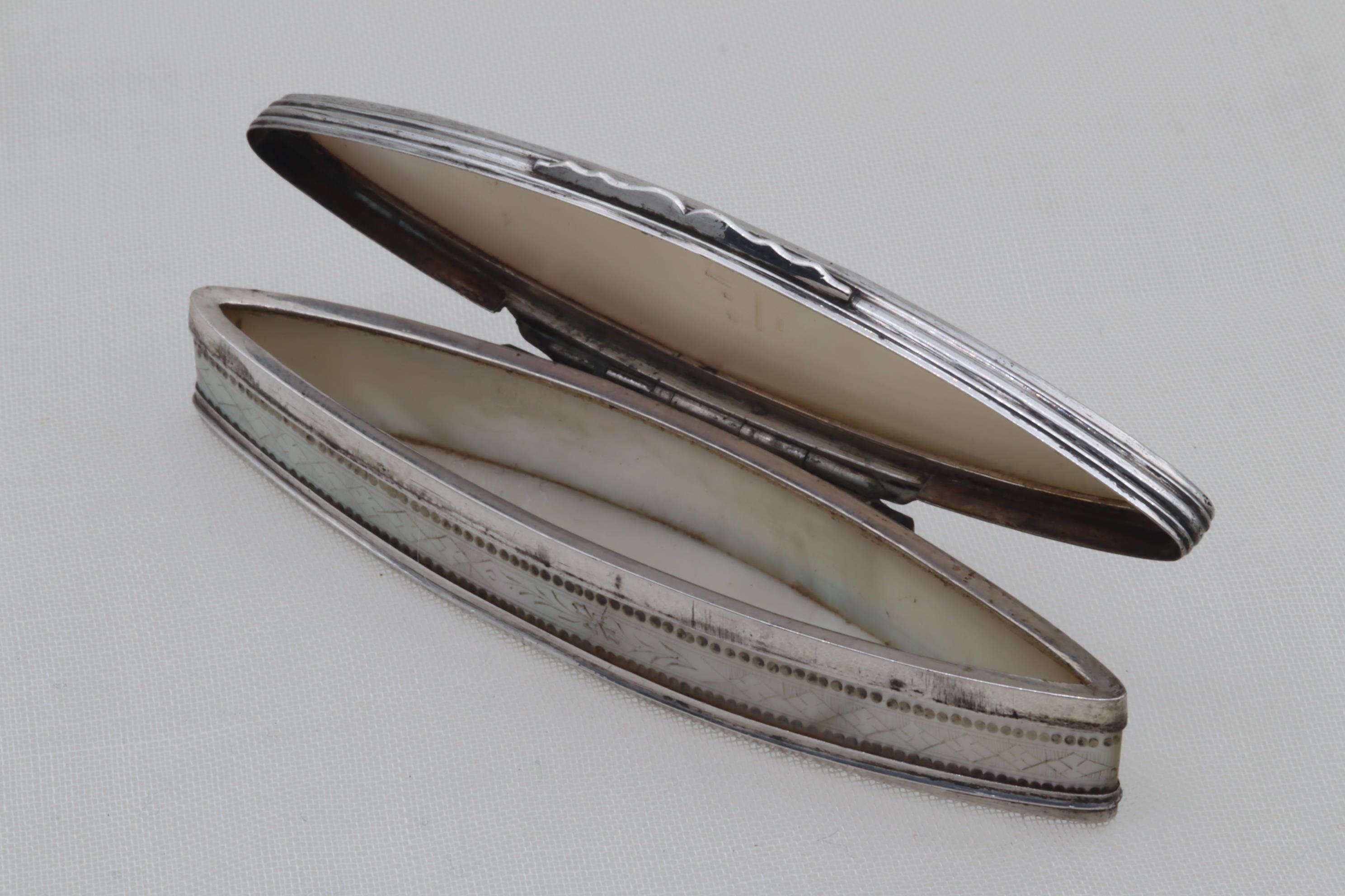 This lovely Georgian ladies toothpick case is an elongated oval in form known as a navette, and is made of a silver frame holding mother-of-pearl panels. The panels for the lid and the two sides are delicately engraved, with the top featuring a