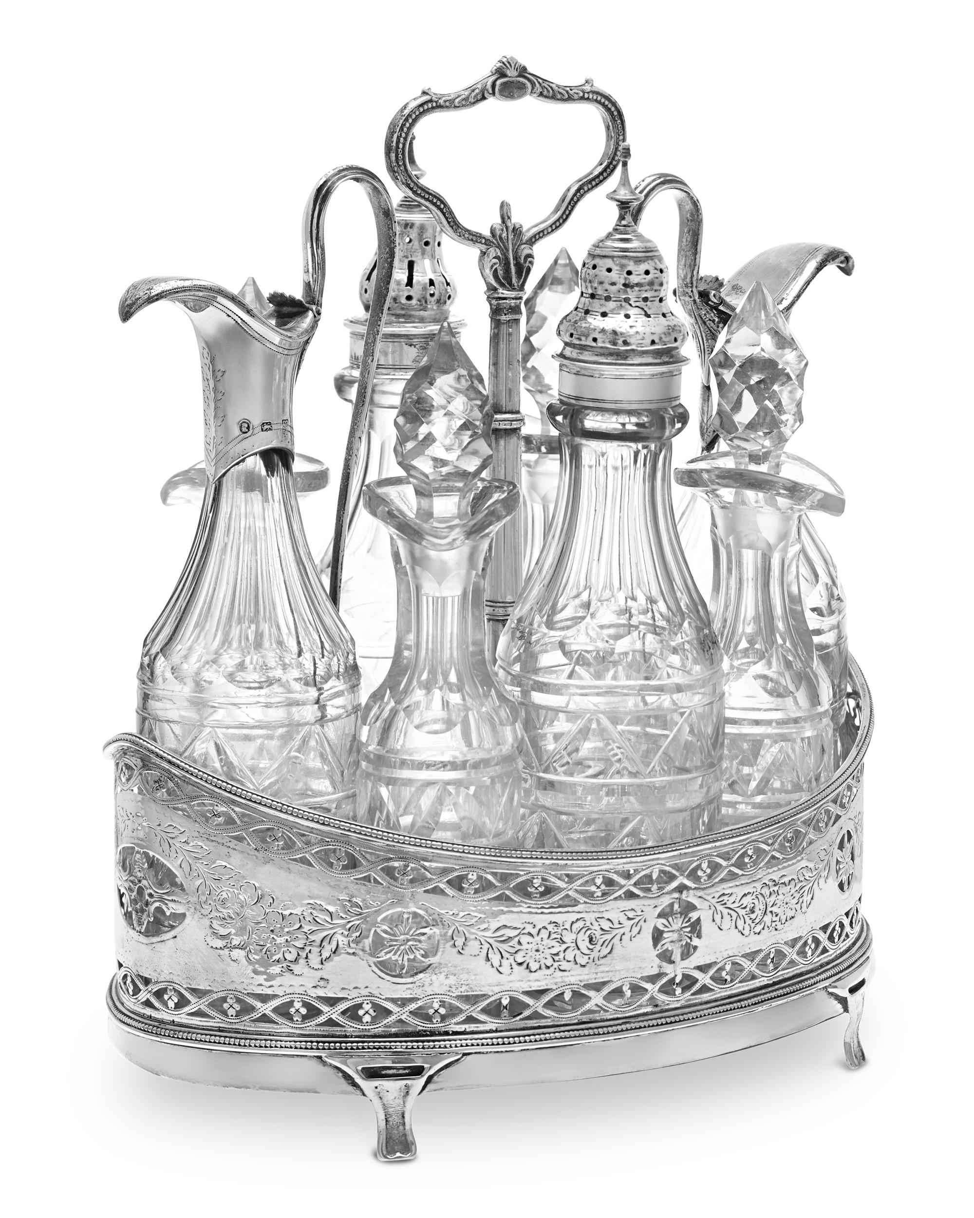 This complete eight-piece silver and crystal cruet set with stand was crafted by the Queen of the Georgian silversmiths, Hester Bateman. Her signature delicate decorative elements are beautifully integrated into the overall design, including