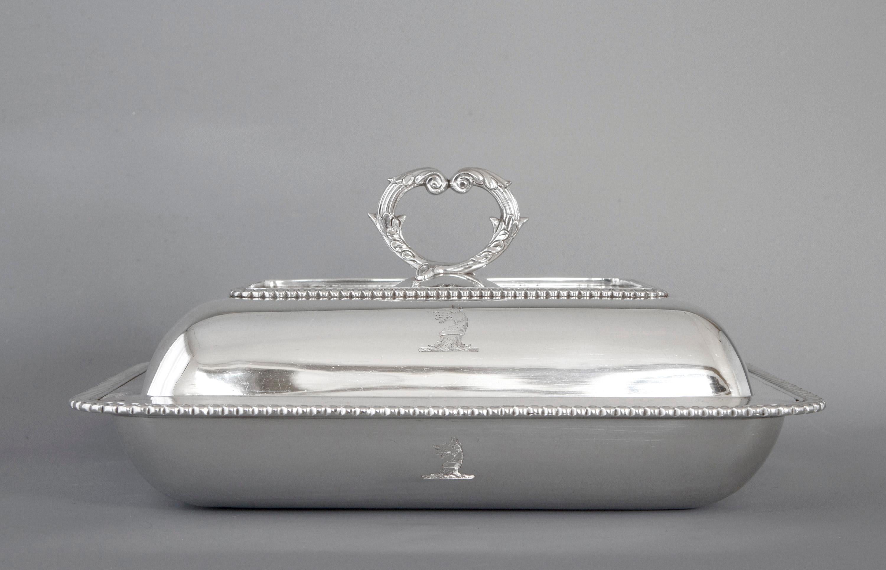 An excellent quality George III solid silver entree dish of shaped rectangular cushion form.
Decorated with gadrooned borders to base and cover, both have an engraved crest see pictures. The removable cast silver handle with matching decoration.
