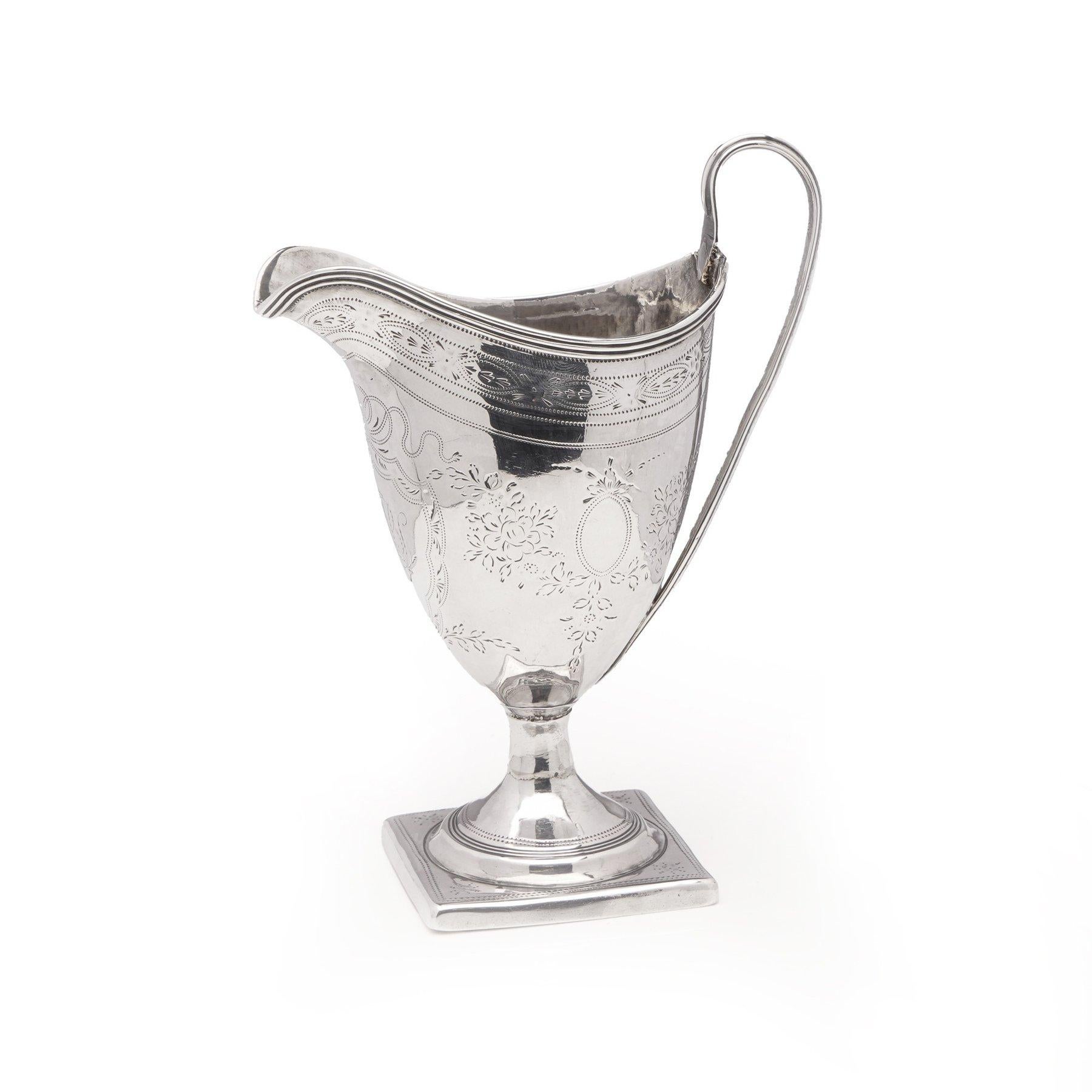 Jarra de crema/leche georgiana de plata sobre base cuadrada.
Decorado con guirnaldas, cartela con iniciales y motivos florales.
Made in England, Londres, 1796
Fabricante: Parcialmente palabra, irreconocible

Dimensiones:
Alto x ancho: 14 x 5,2