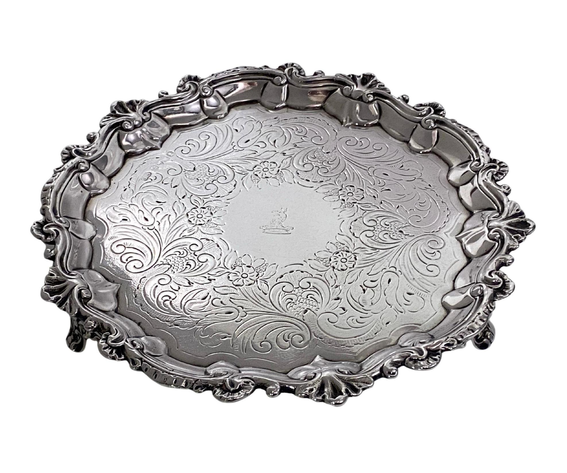 Georgian silver salver London 1827 William Brown. The salver on three foliage feet, shell and scroll foliage border, and flat chased decoration and engraved crest in the centre of a wolf's head erased out of a ducal coronet. Diameter: 8.50 inches.