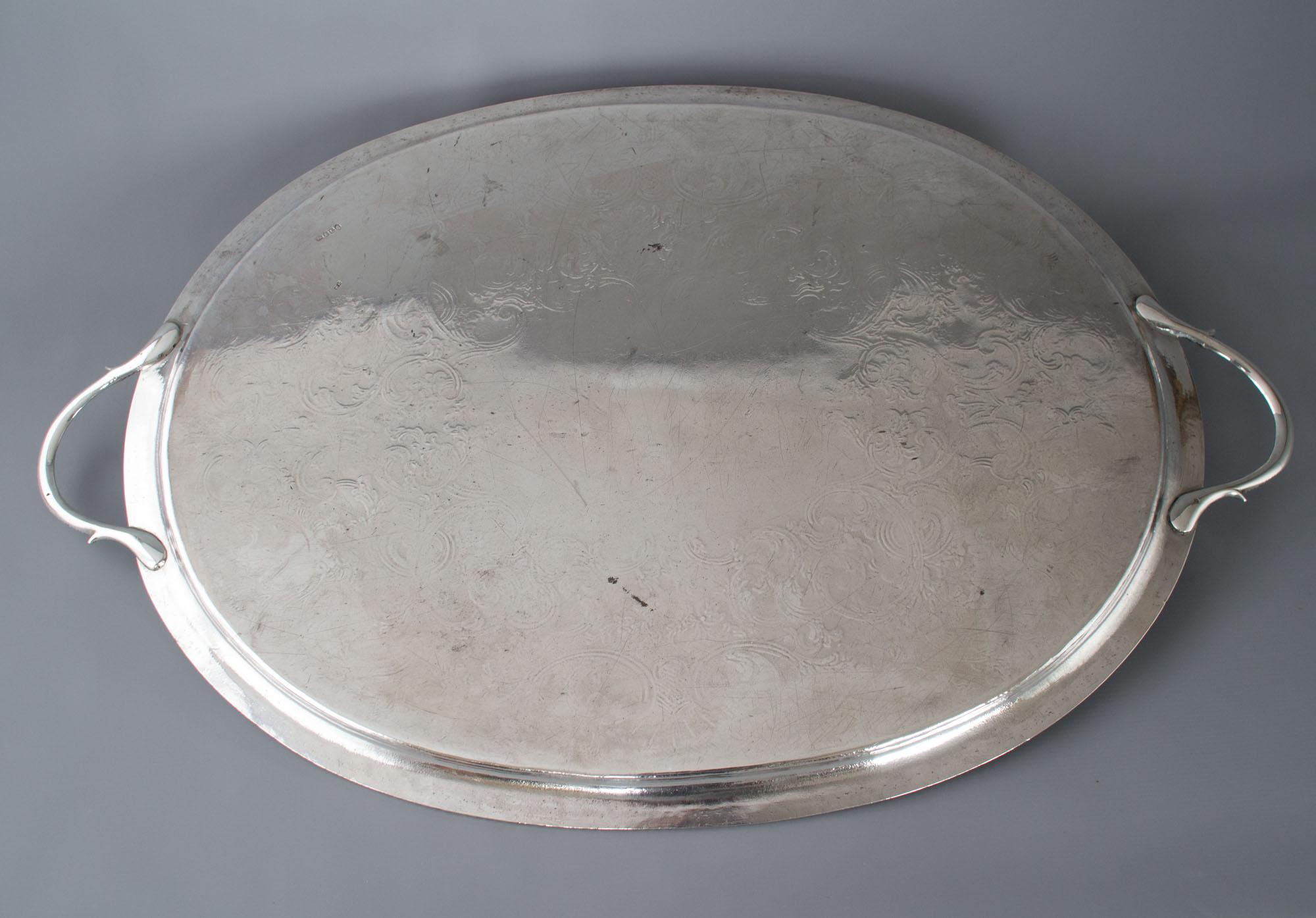 A superb high quality twin-handled George III silver tray of oval form. The cast and applied border with gadrooned rim. The two handles of conforming pattern. The central plate with an armorial in a shield beneath a dragon and the Latin inscription: