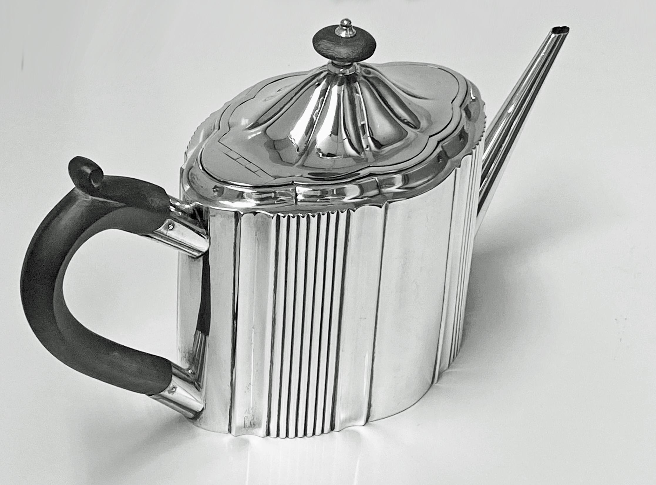 A fine and elegant Georgian sterling silver teapot, London 1794, with maker's mark for Robert Hennell I. The teapot of oval ribbed panel form with domed lid, ebony wood handle and silver topped ebony finial, straight spout. Fully hallmarked to base