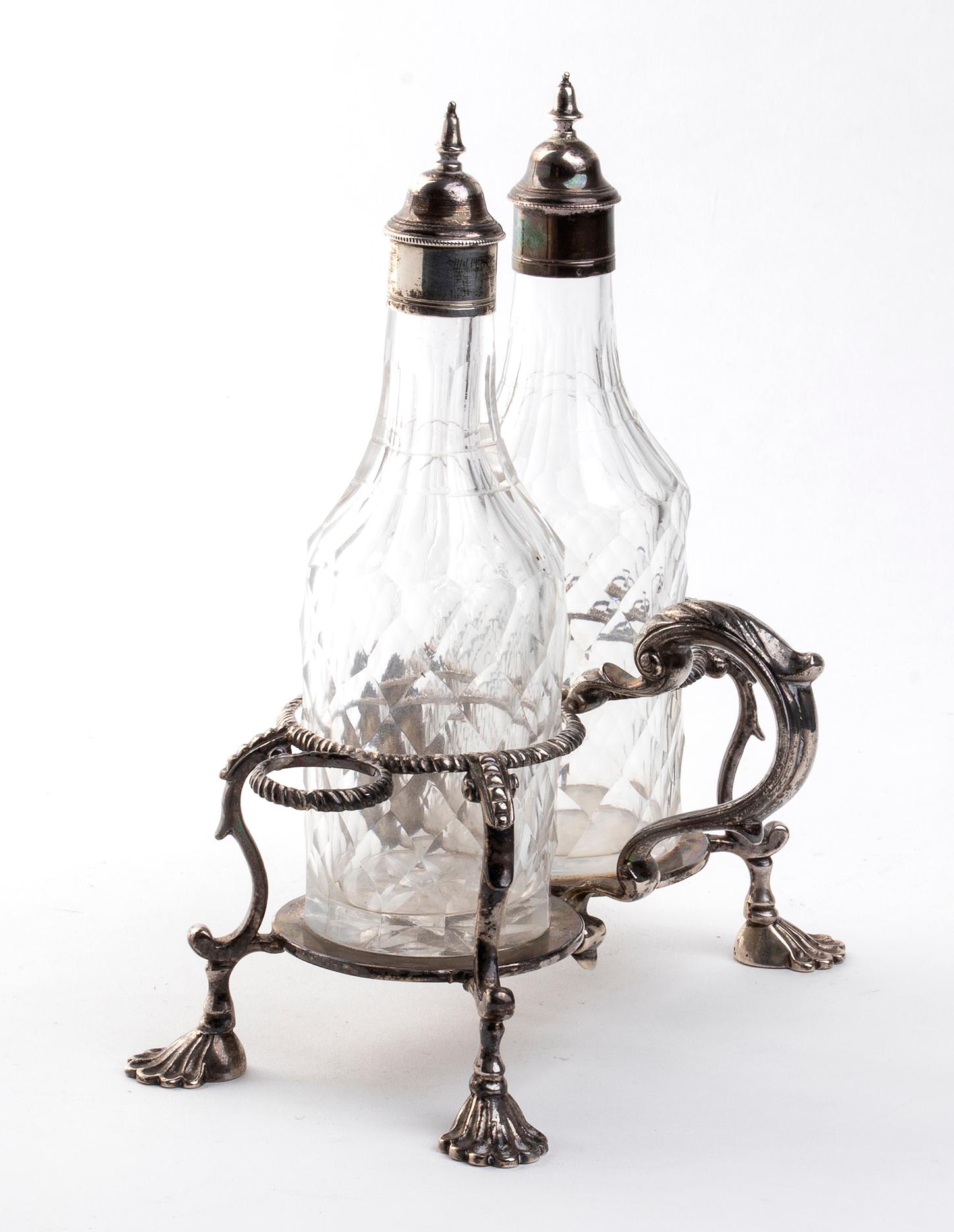 You are admiring a striking Georgian silver vinegar ampoule, realized in London in 1766.

Made of 925/1000 silver.

This elegant vinegar ampoule is formed by a decorated stand resting on four seashell feet containing two ground glass
