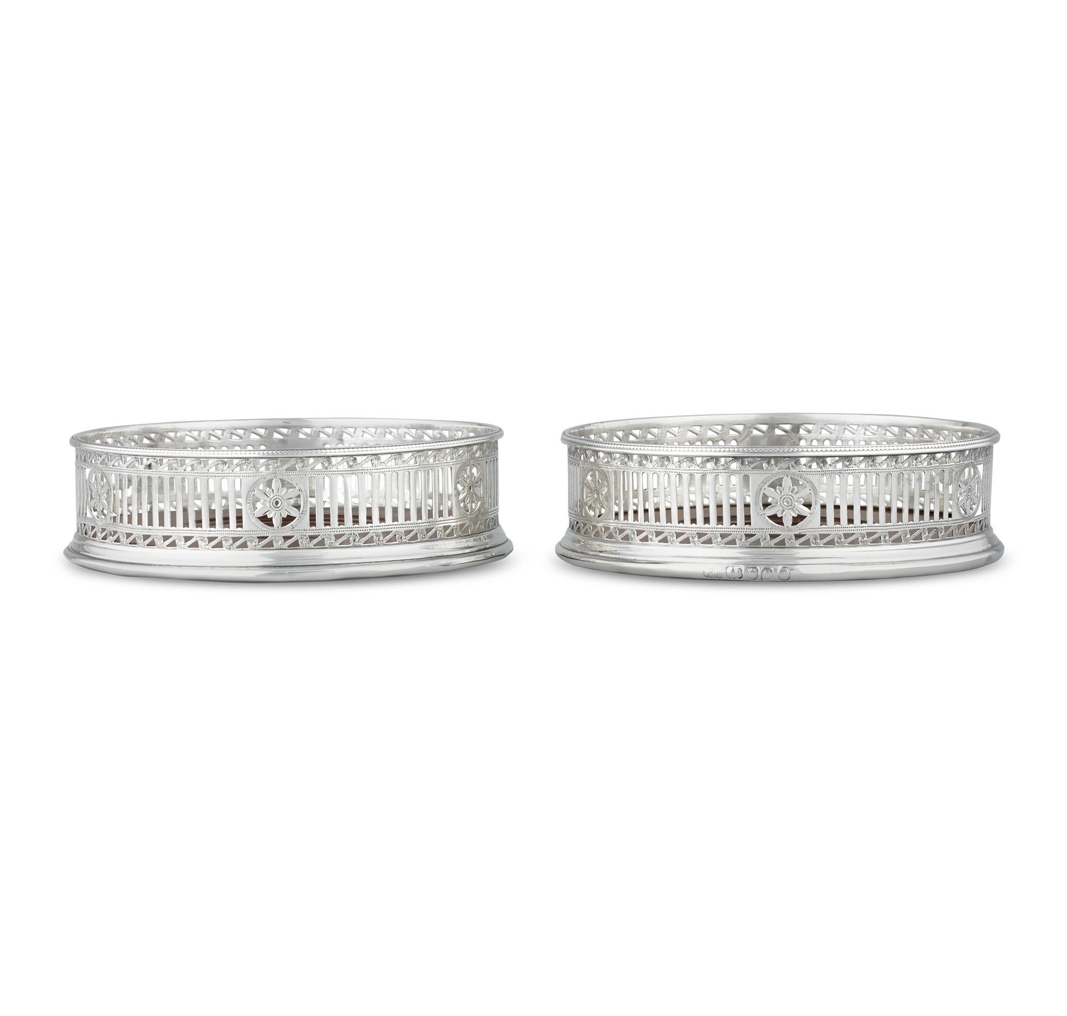 Posavasos para vino de plata de ley
Hester Bateman
Hallmarked Londres, 1793

Este exquisito par de posavasos de plata de ley de la época de Jorge III es obra de la legendaria Hester Bateman. Cada diseño presenta un bello borde calado con motivos