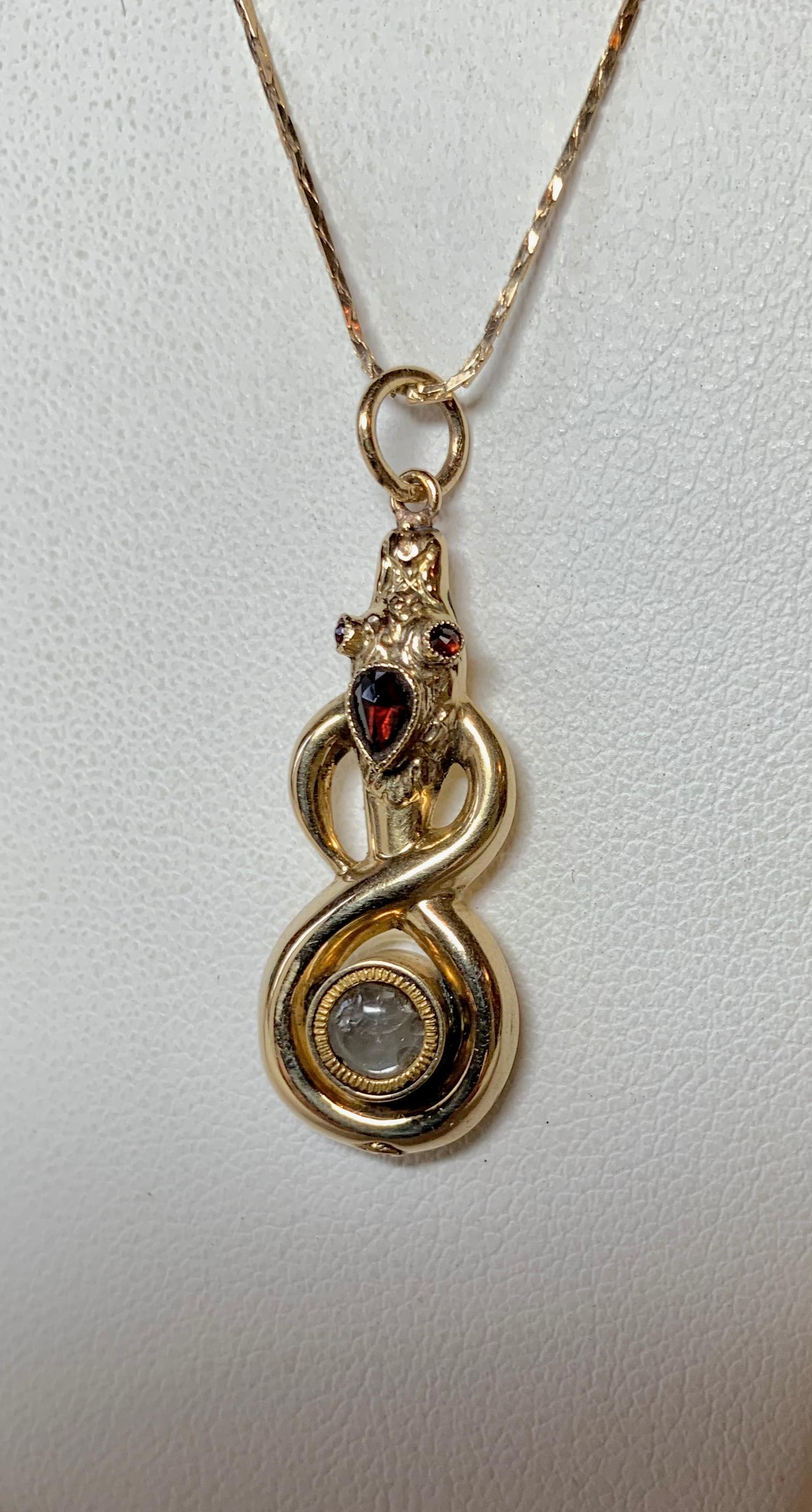 A very rare antique Georgian to Victorian Snake Pendant Locket with a small hinged Locket opening in which to place a treasured memento, a mourning item, or possibly poison!  The extraordinary Snake Pendant is 14 Karat Gold.  The head and eyes of