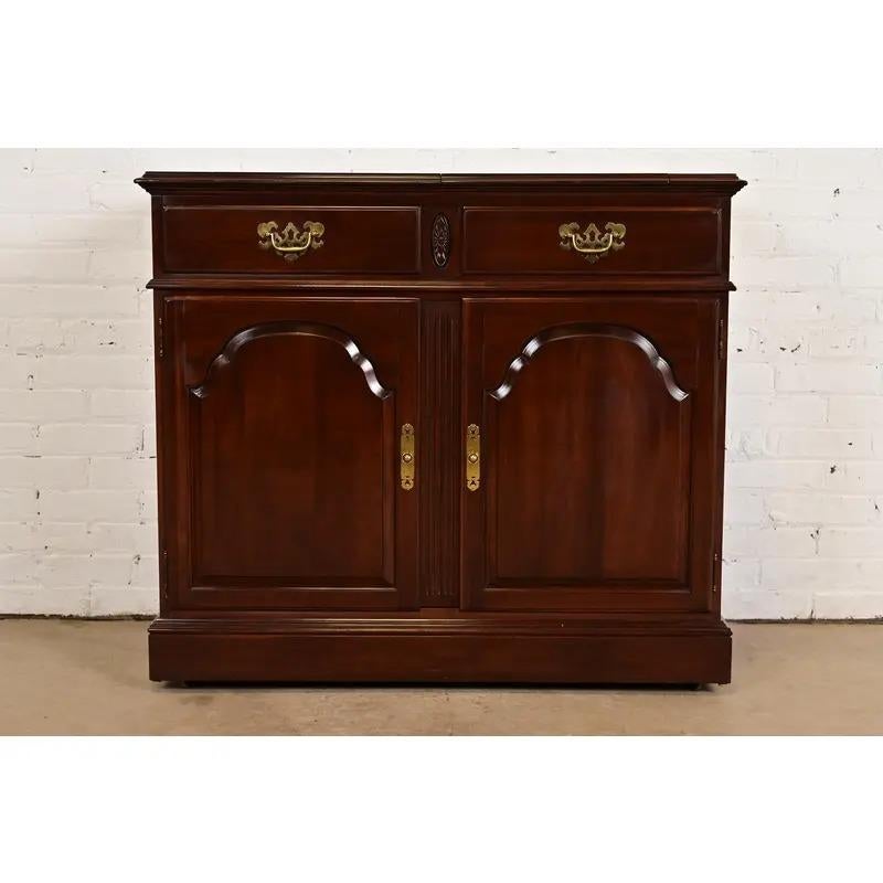 A beautiful Georgian or Chippendale style flip top rolling buffet server or bar cabinet

USA, Circa 1980s

Carved solid cherry wood, with original brass hardware.

Measures: 40