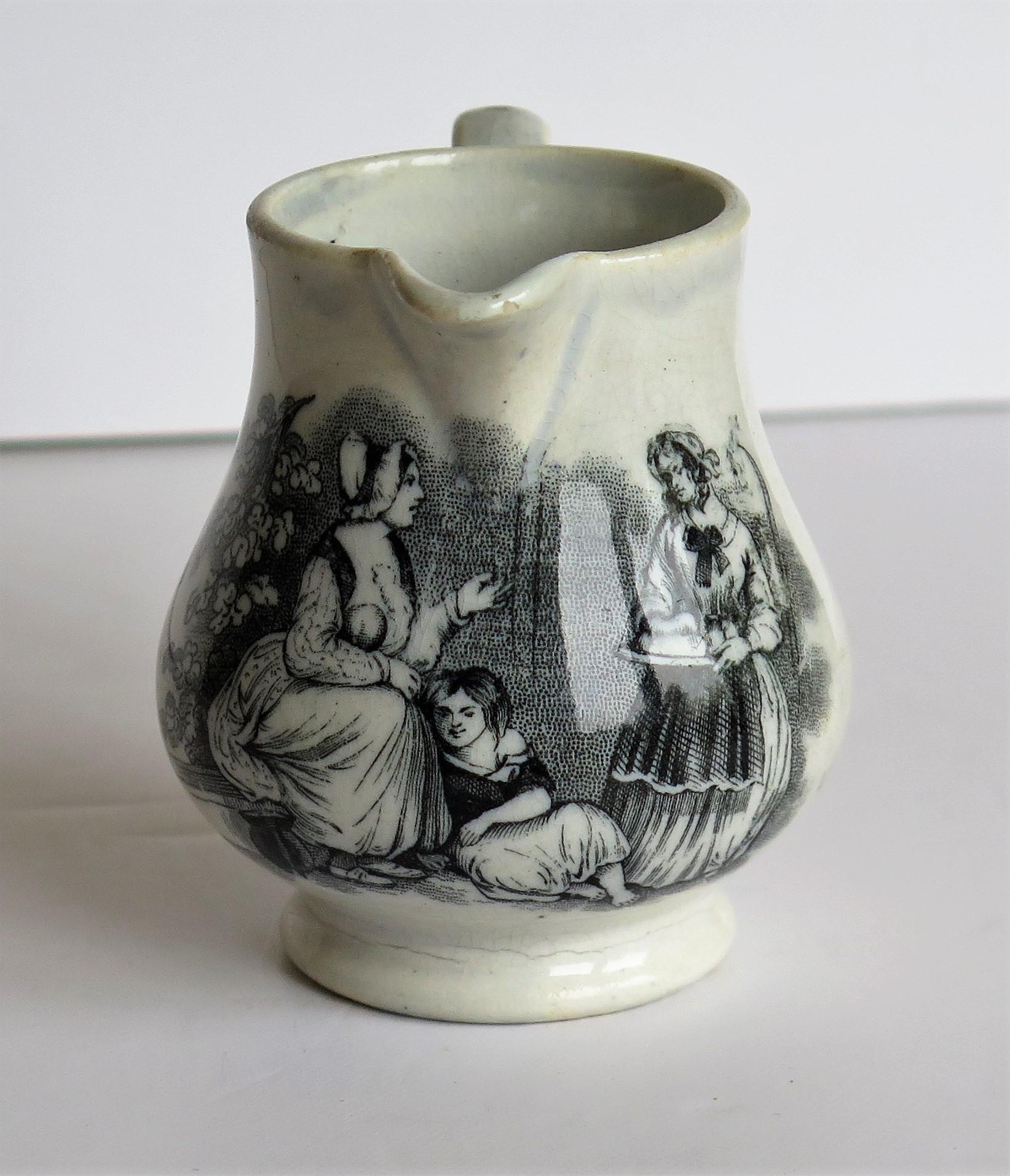 This is an early Pearlware cream Jug with a bat-printed family scene made by a Staffordshire potter in the early 19th century, late Georgian period, circa 1815.

The jug has a baluster pear shape on a low foot and a loop handle. The glaze is