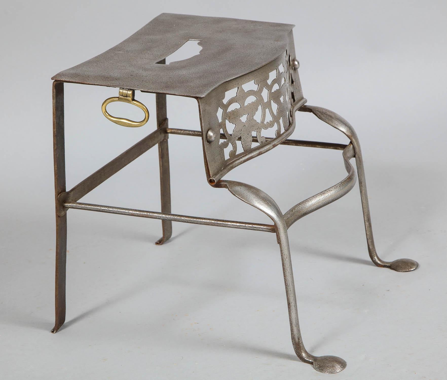 Fine George III period steel trivet having pierced top and frieze and having brass handles over gunmetal steel base, the front cabriole legs ending in penny feet.



