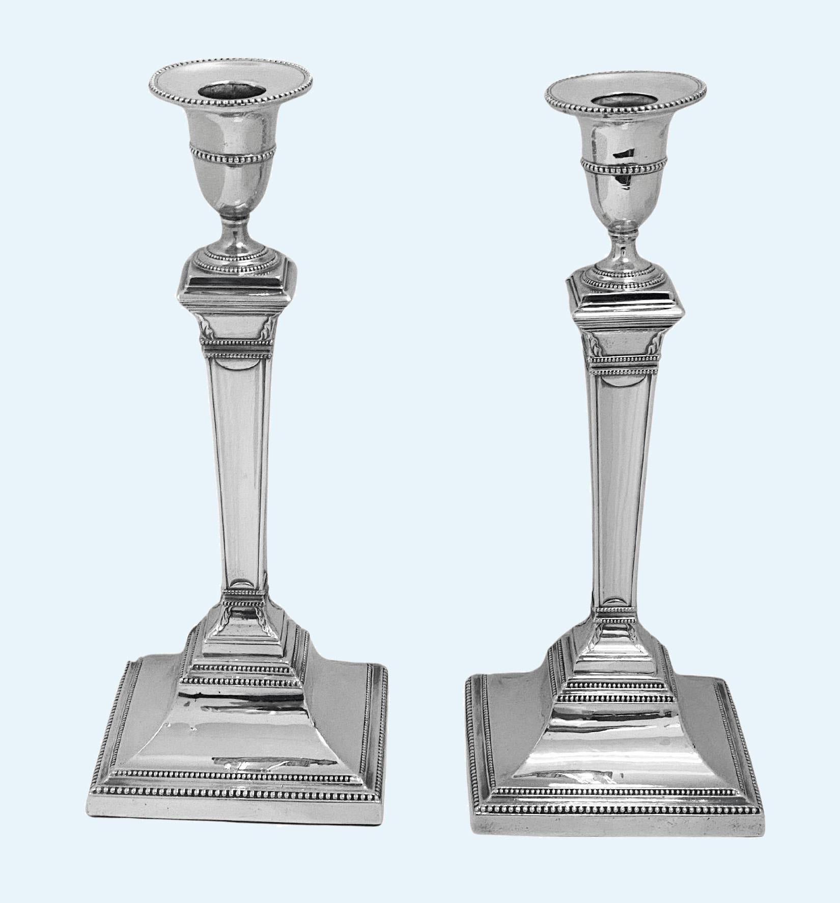 Candeleros georgianos de plata de ley del siglo XVIII Hallmarked Sheffield 1780 por John Younge and Co. Los candeleros, de estilo neoclásico, tienen bases cuadradas escalonadas con bordes de abalorios que se elevan hasta los tallos cónicos lisos,