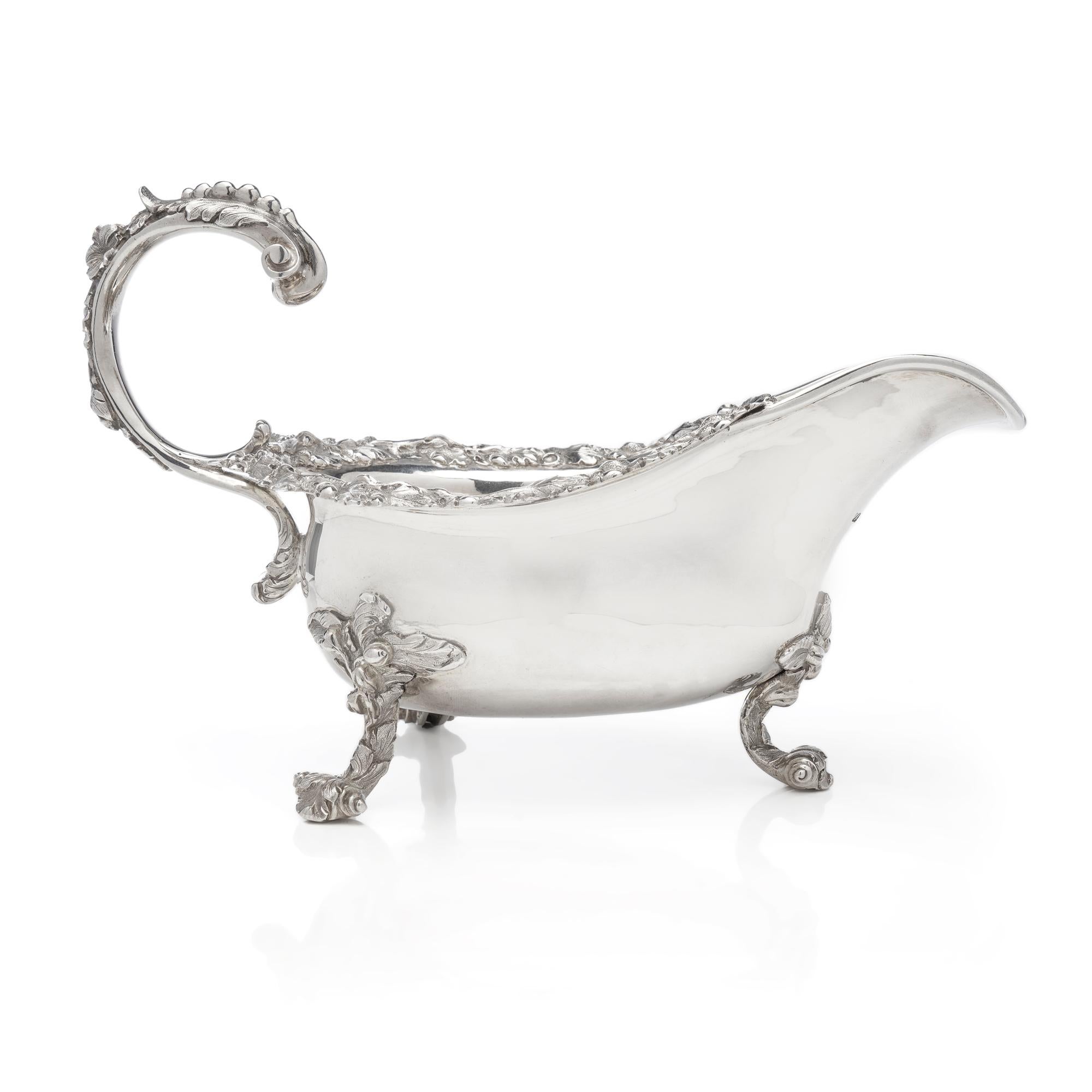 Antique Georgian sterling silver chased sauce boat with elaborate decorations, featuring Oak leaves with acorns. 
Made in England, London, 1827
Maker: James Arthur
Fully hallmarked. 

Dimensions - 
Length x width x height: 23 x 12.5 x 15 cm