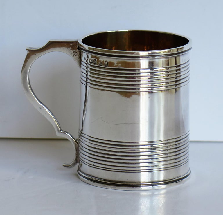 This is a very good, sterling silver mug or Christening Mug made in the late Georgian, George IVth Regency period, by Joseph Angell 1st of London, in 1825.

The mug is handmade and has a slightly tapered body with a notched loop handle. It has